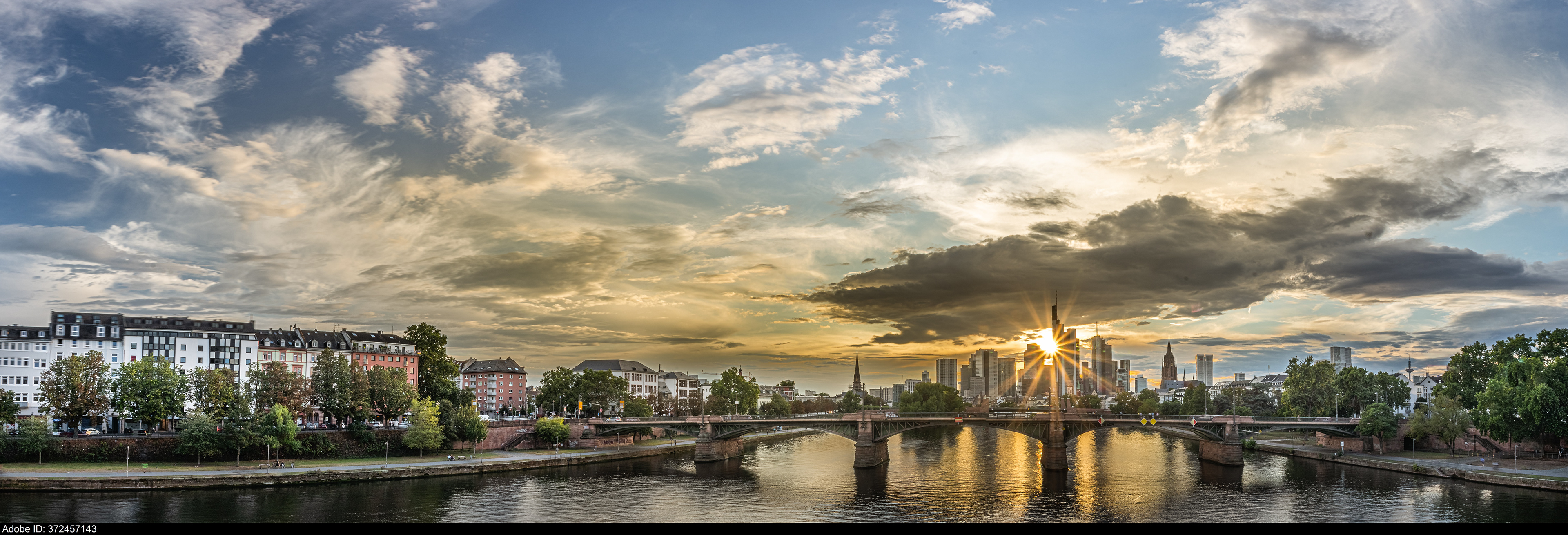 372457143  high resolution photo with sunbeams and sunrays shining through buildings during frankfurt germany skyline sunset