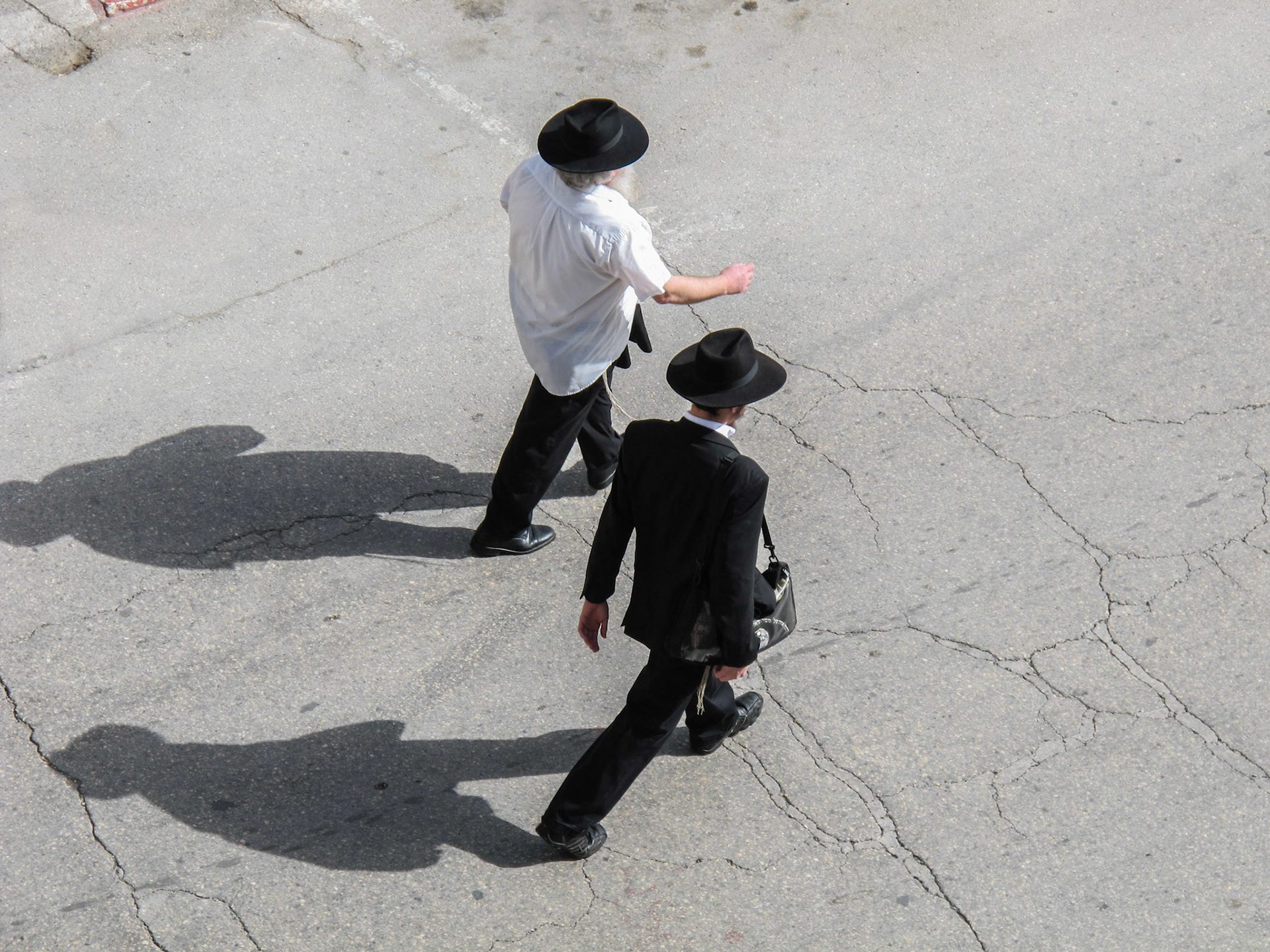 Passersby walking below the Ramparts Walk in Jerusalem.