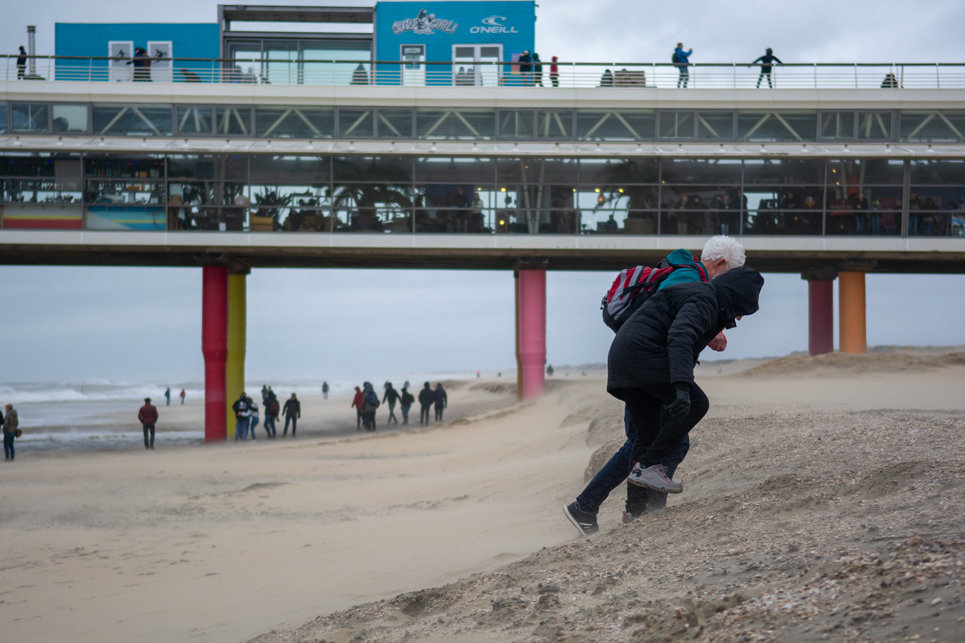 Mensen trotseren de sterke wind op het strand van Scheveningen tijdens de strom Ciara