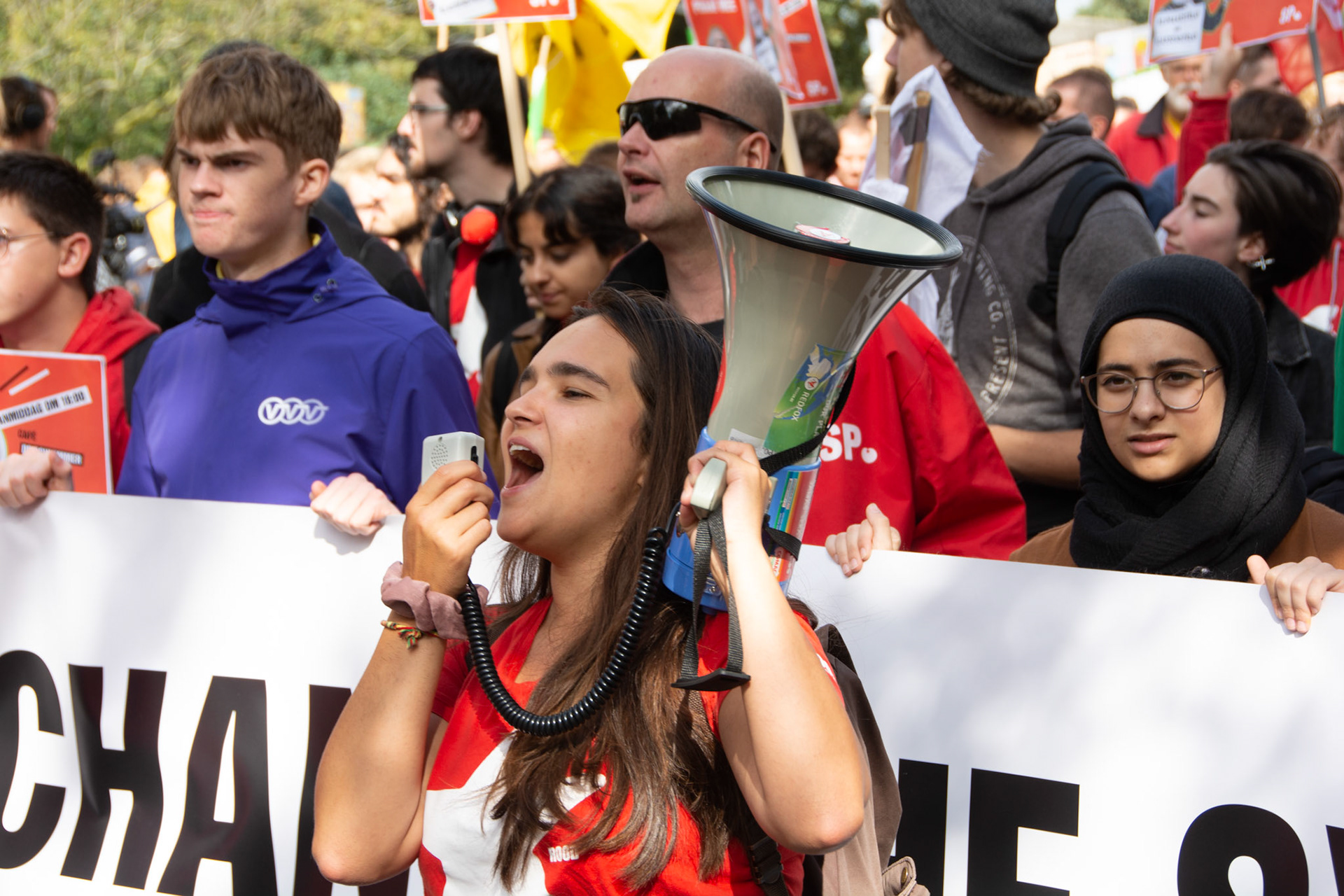 Klimaatdemonstrant schreeuwt leuzen door megafoon
