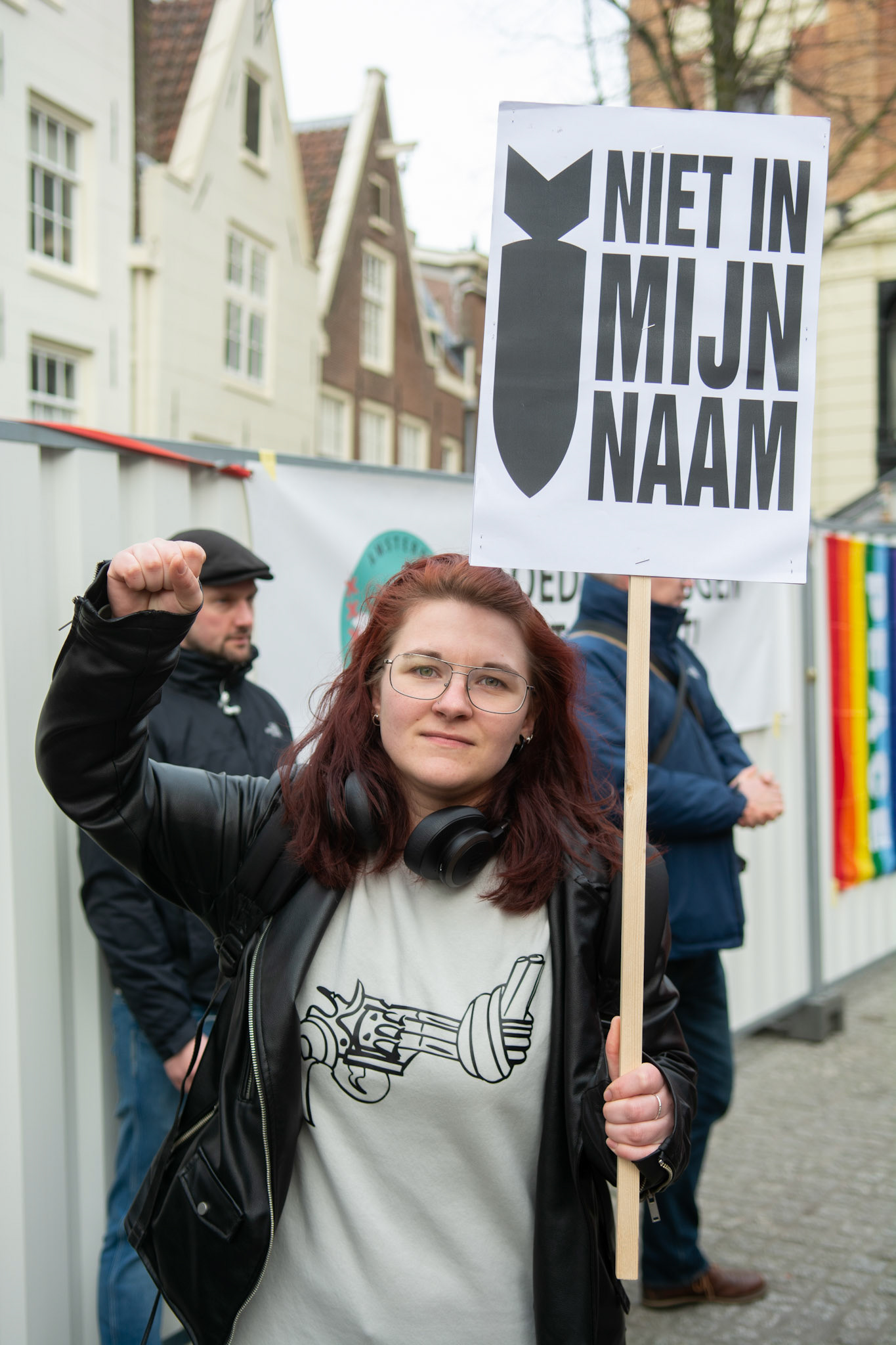 Demonstrant van ROOD, jong in de sp poseert met haar protestbord
