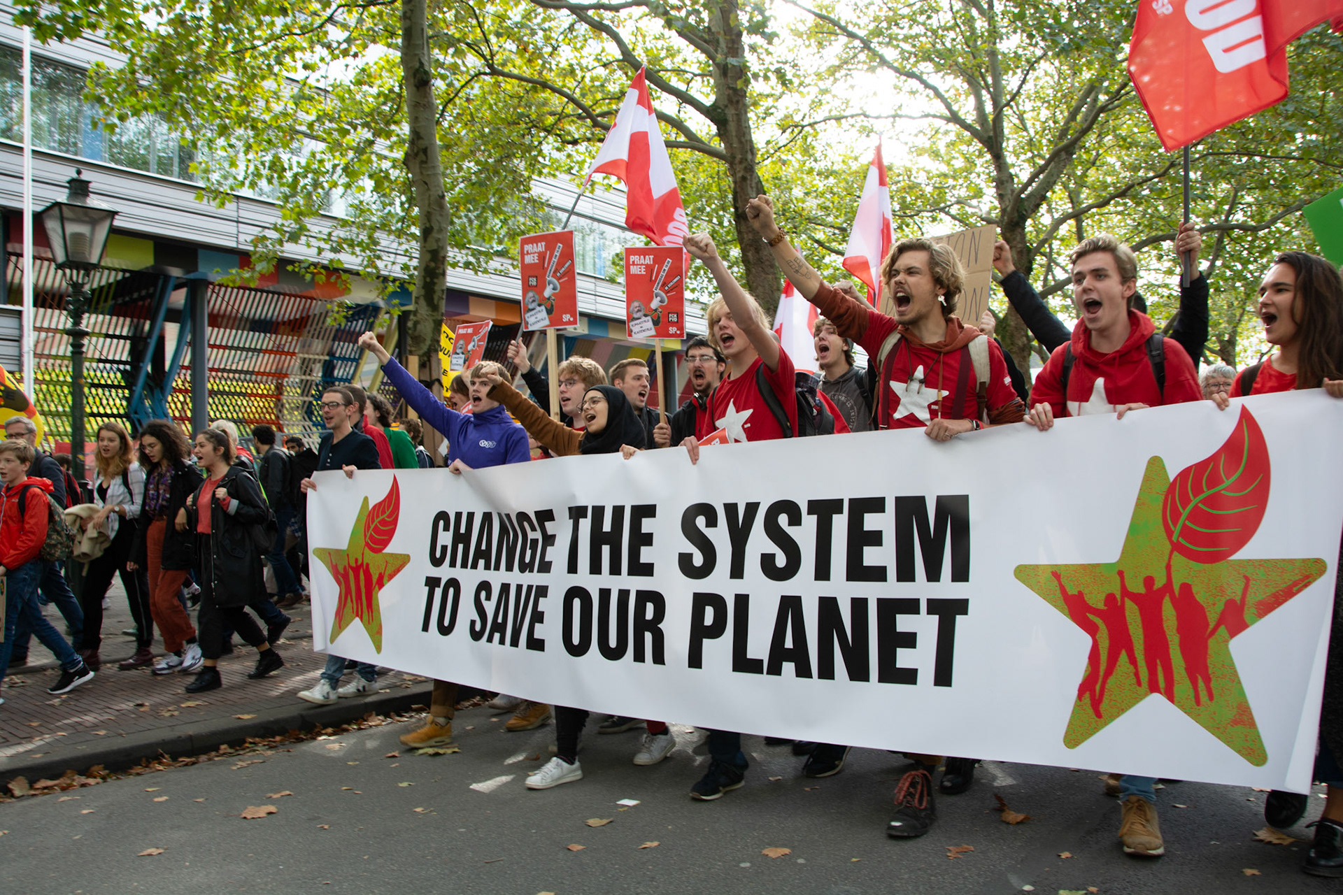 Klimaatdemonstranten met banner "change the system to save our planet"