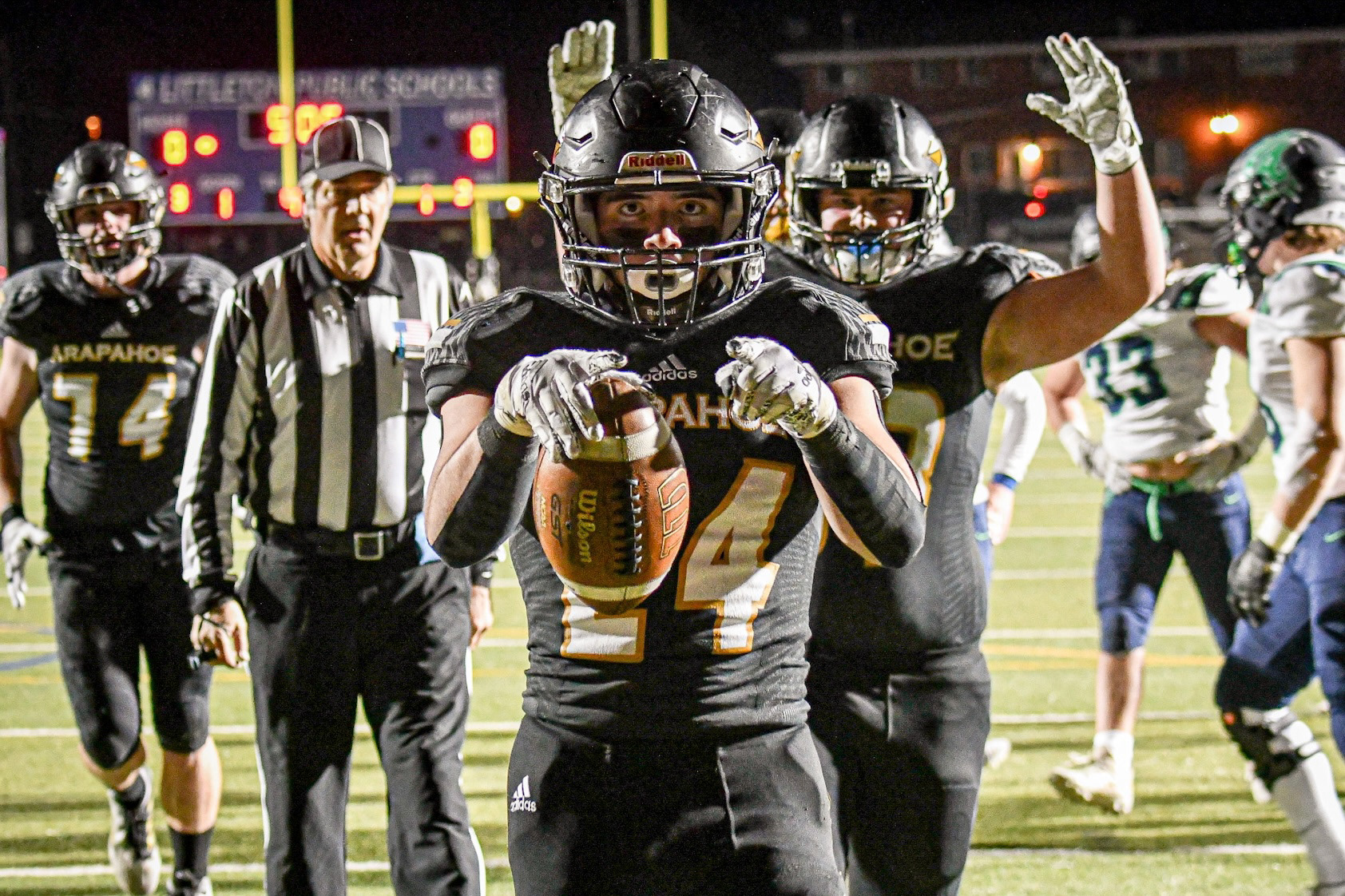 After scoring a touchdown under the Friday night lights against ThunderRidge high school, senior DJ Montoya celebrates with his team. The Arapahoe Warriors defeated the ThunderRidge Grizzlies 23-16 in the second round of the CHSAA 5A Colorado football playoffs. 