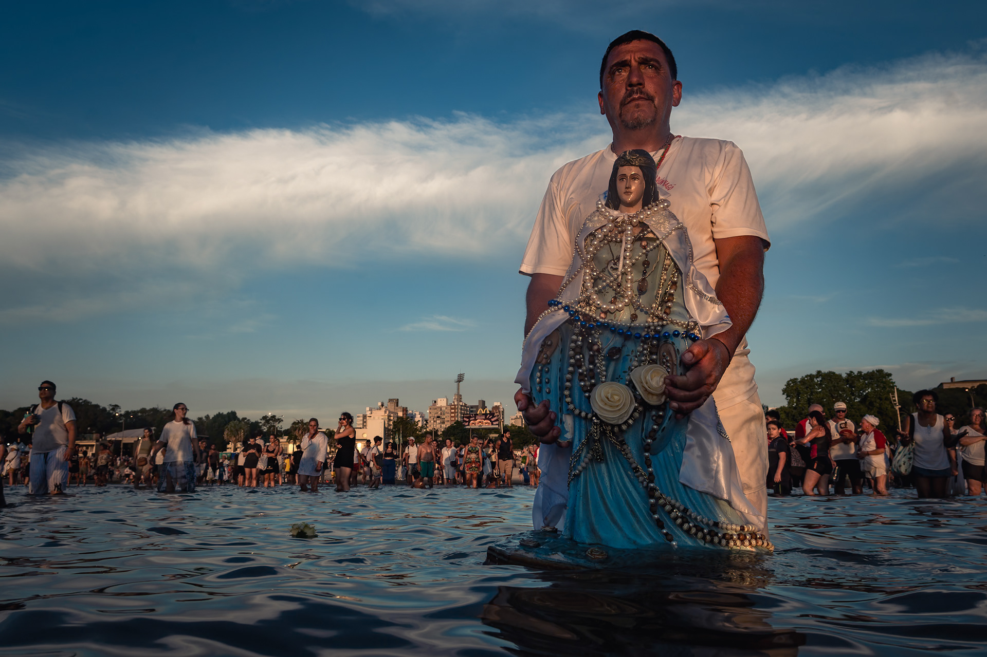 Un devoto sostiene una estatua sobre el mar durante la celebración de Iemanjá, en la Playa Ramírez de Montevideo. 2 de febrero de 2024.