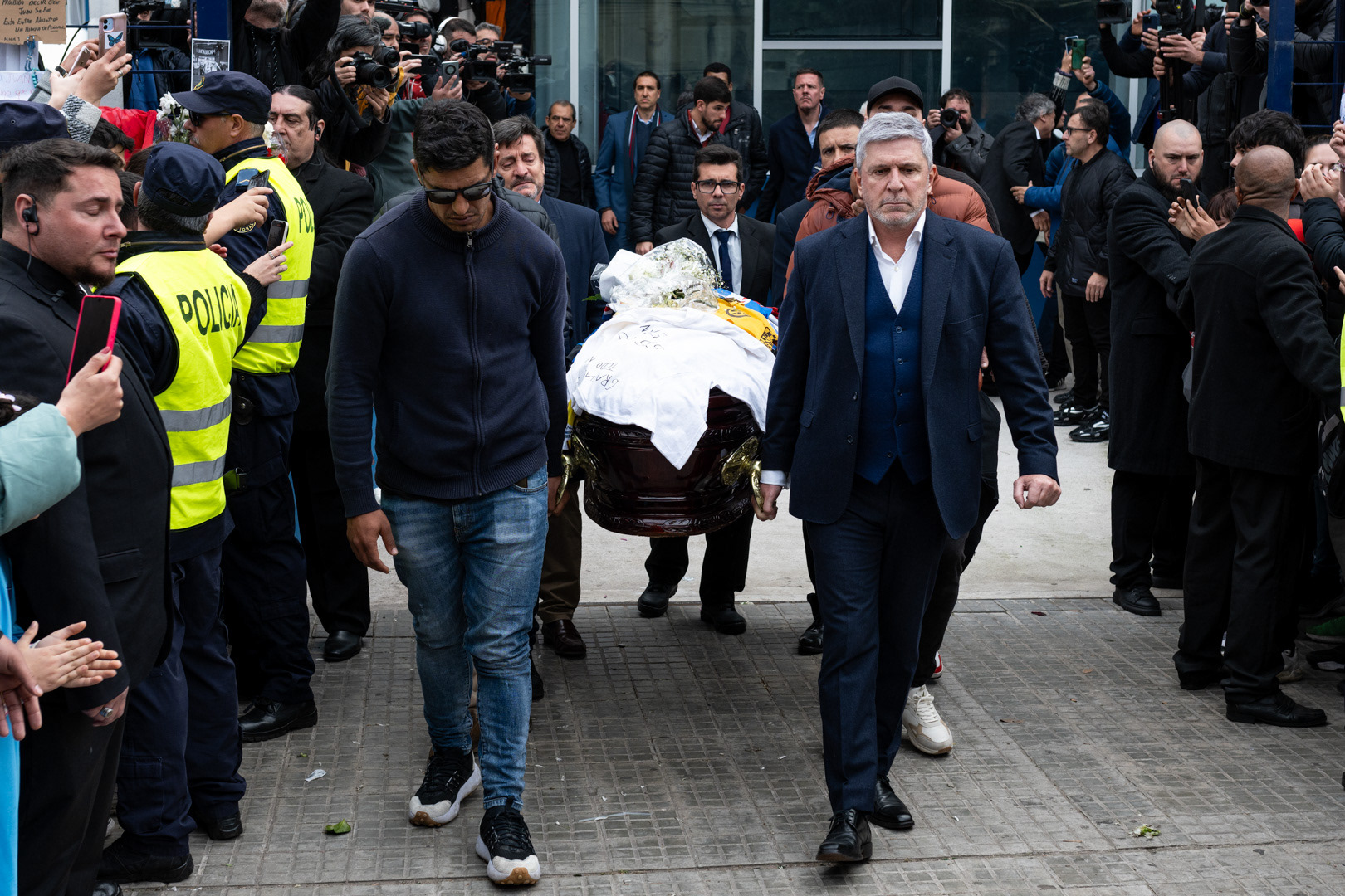 El capitan de Nacional, Diego Polenta, y el presidente de Nacional, Alejandro Balbi, cargan el cajón que contiene los restos del futbolista Juan Izquierdo, durante su cortejo fúnebre en la sede del Club Nacional de Football. 29 de agosto de 2024.