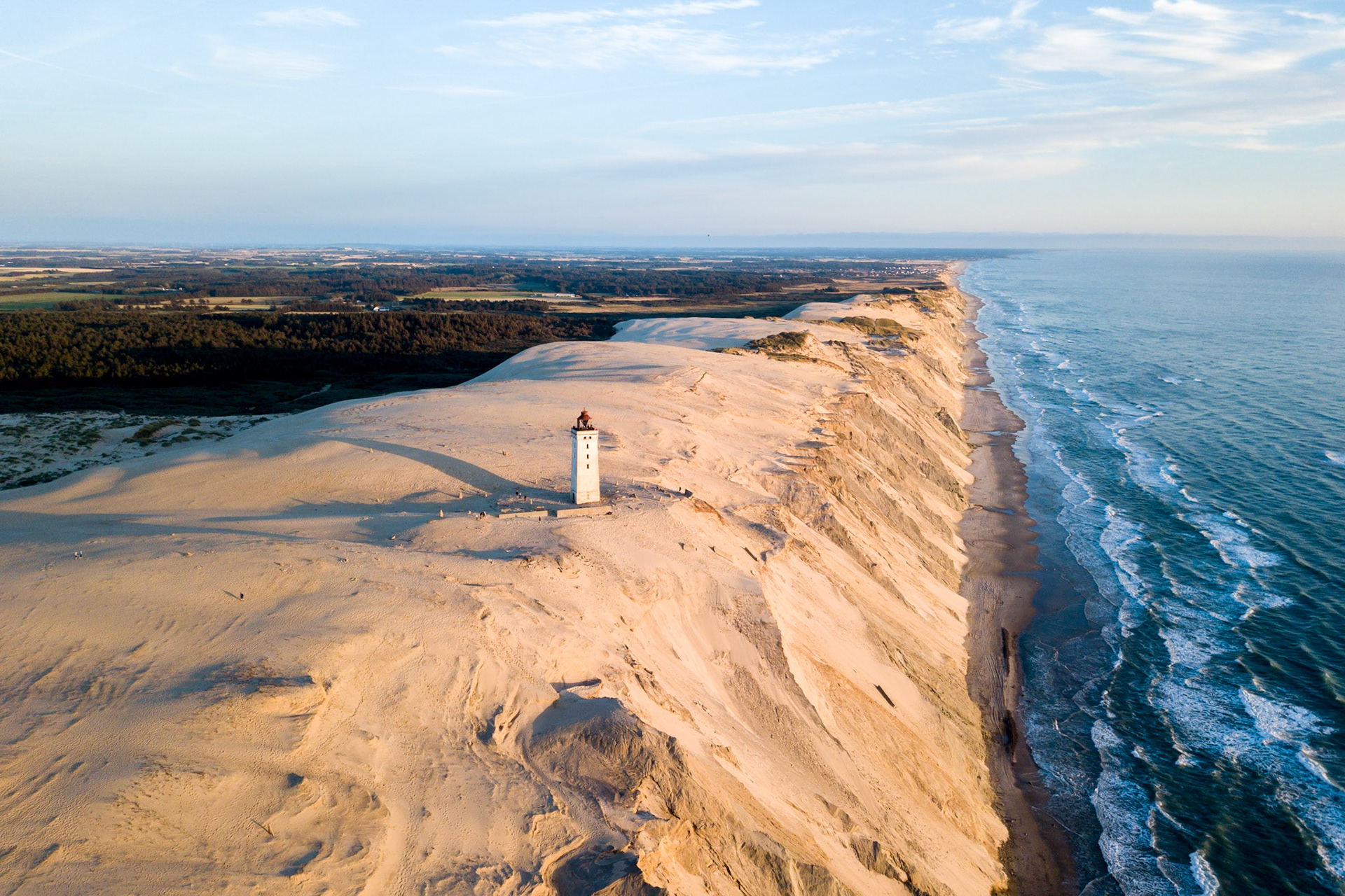Lokken, Denmark - July 15, 2019: Aerial drone view of Rubjerg Knude Lighthouse and sand dunes.