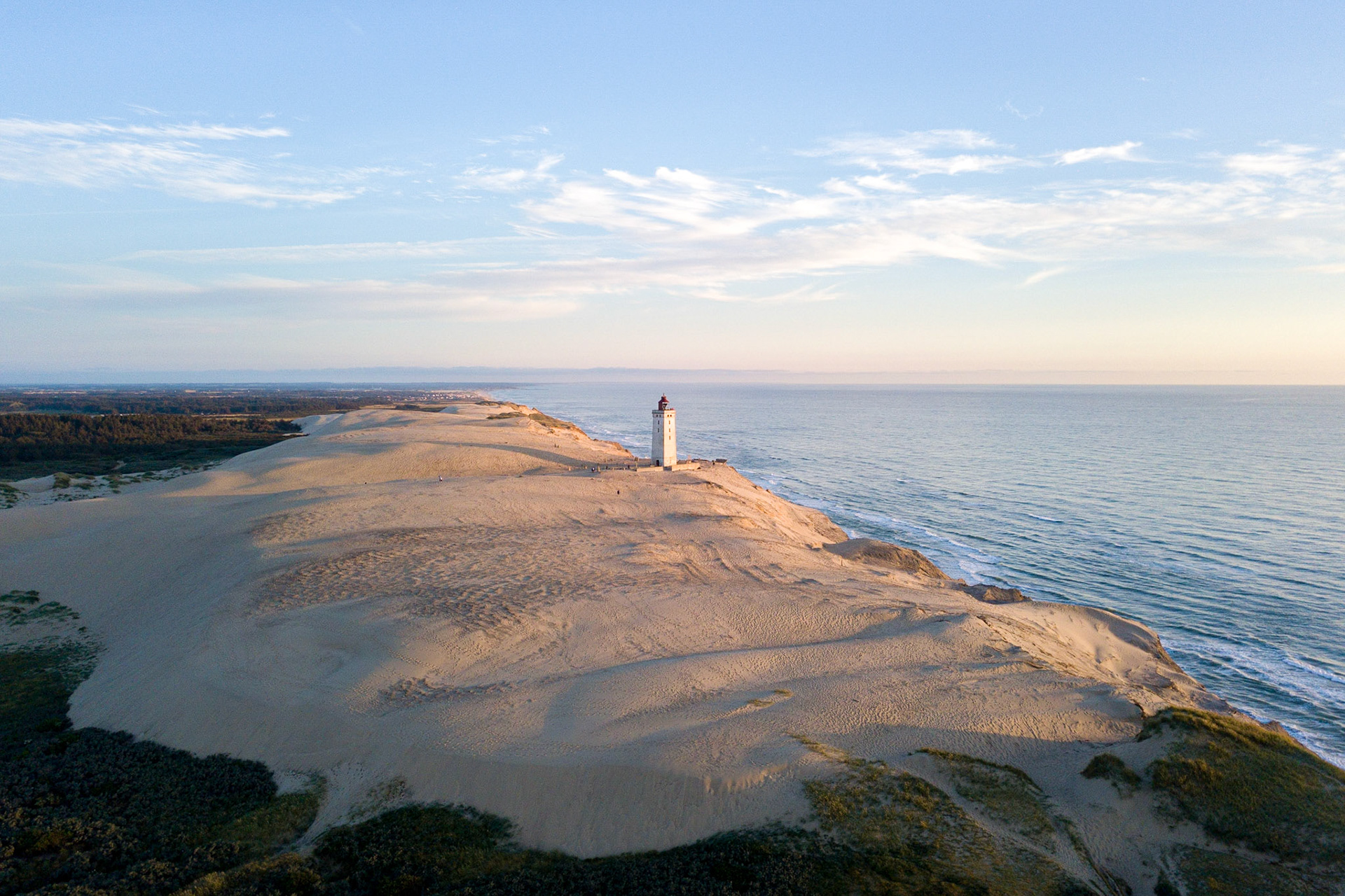 Lokken, Denmark - July 15, 2019: Aerial drone view of Rubjerg Knude Lighthouse and sand dunes.