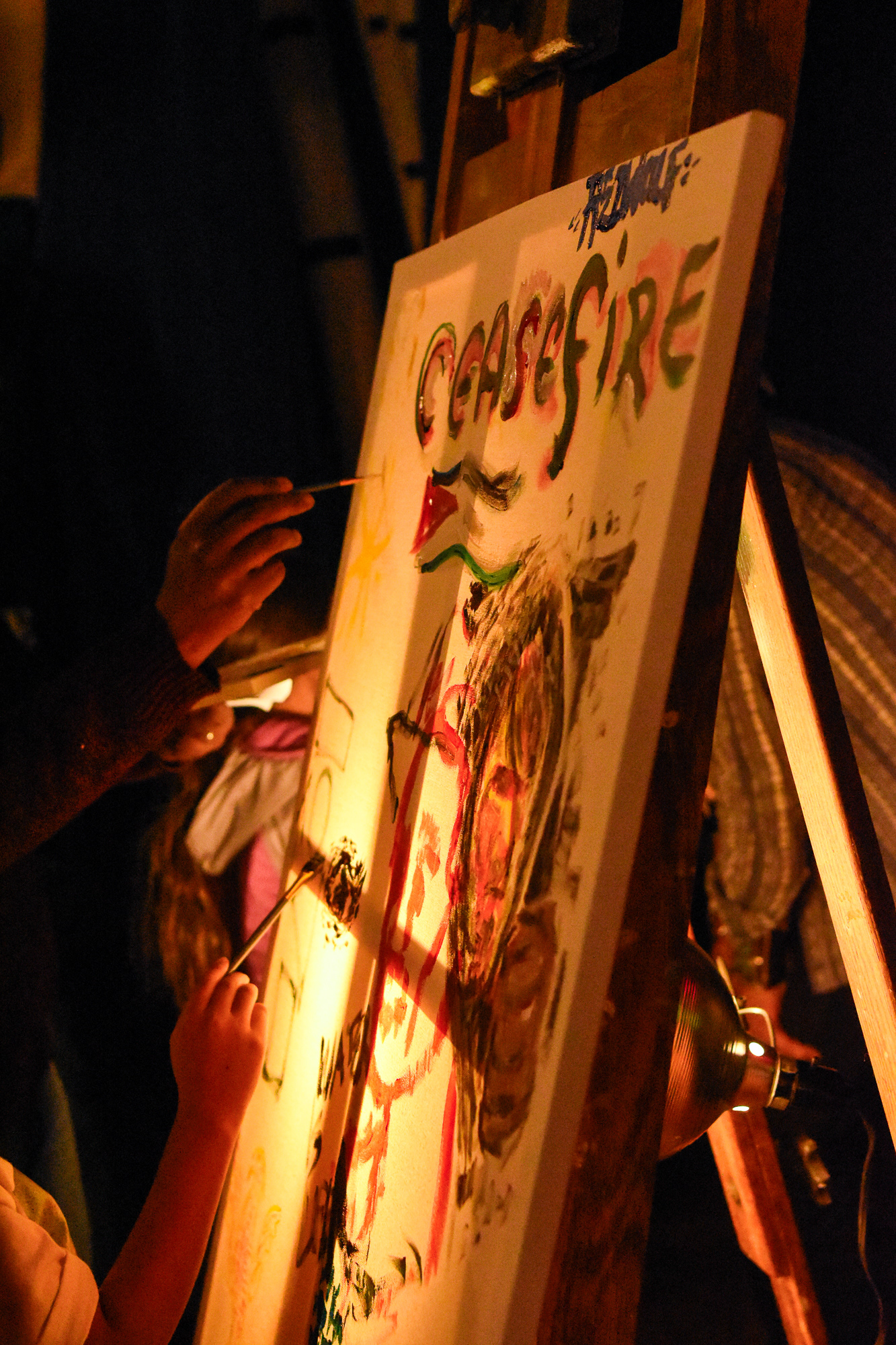 Participants paint a communal canvas displayed at the Klee Benally celebration of life event in the Orpheum Theater, Jan. 6. 