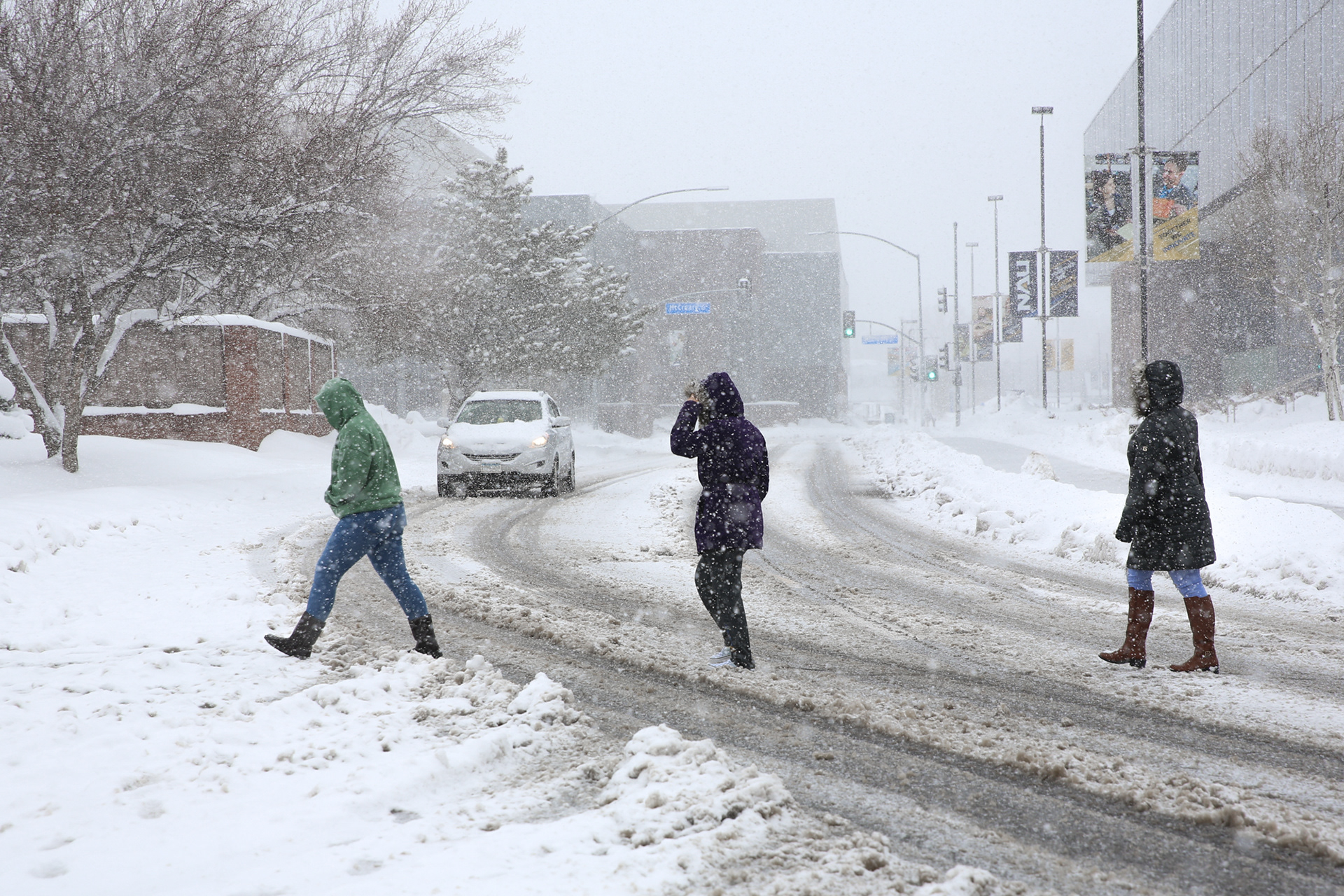 Andrea Telez, Paola Ayala, and Celeste Ayala cross South San Francisco Street during a snow storm in Flagstaff,  Arizona, March 1.
