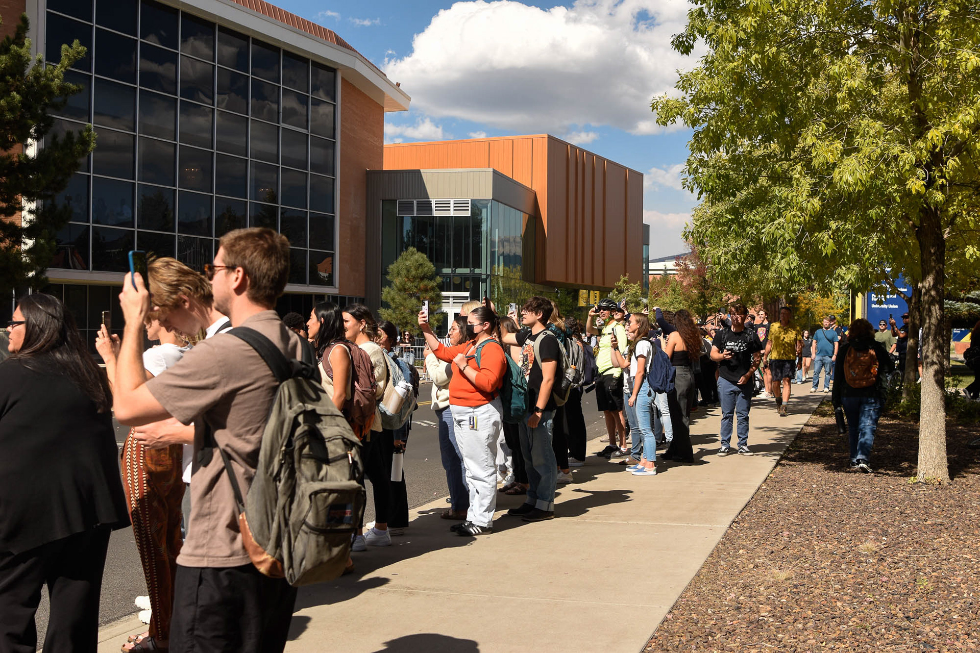 Students outside of the Kitt School of Music film Vice President Kamala Harris' arrival to NAU campus for her speech as part of her "Fight for Our Freedoms College Tour," Oct. 17.
