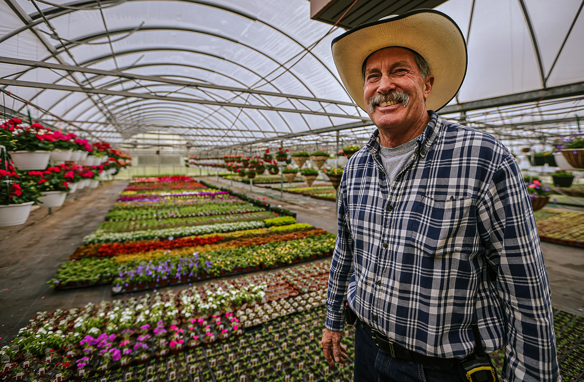 Tom Wardell in front of flowers in his greenhouse at family-owned Wardell’s Garden Center in Waterville, Ohio on Friday, April 15, 2022. For Toledo Blade.