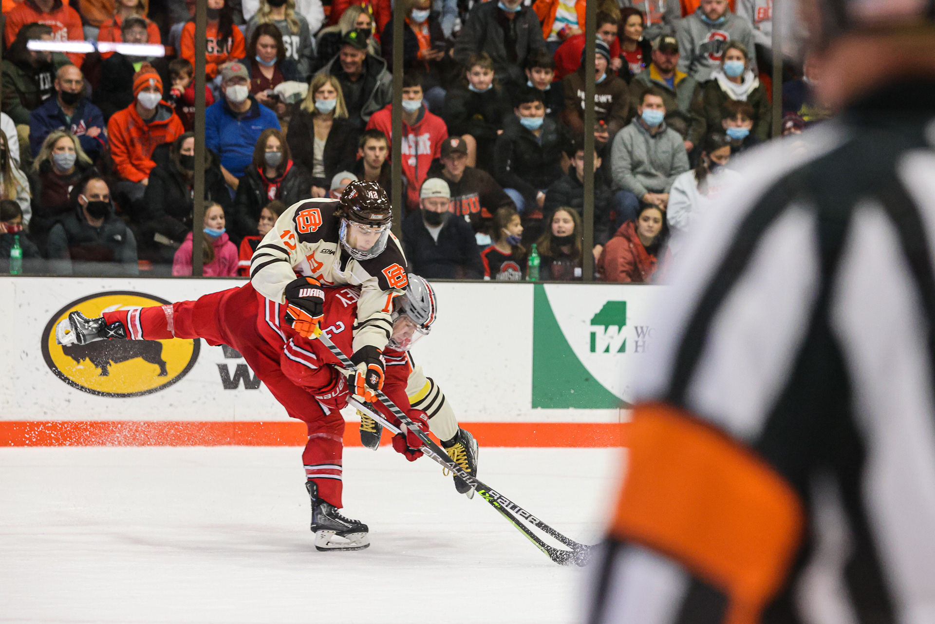 BGSU forward Austin Swankler (12) is thrown over the shoulder of Ohio State’s James Marooney (2) as he pummels into him for the puck at Bowling Green State University on Friday, December 17, 2021. For Toledo Blade. 