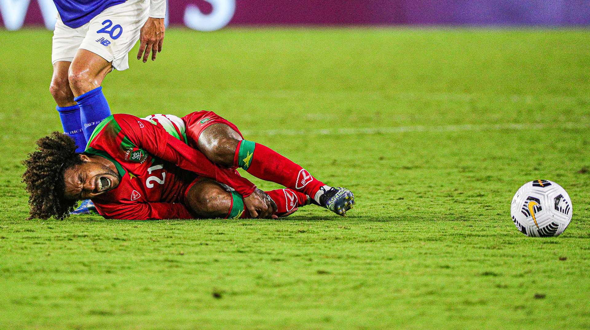 Suriname Attacking Midfielder Diego Biseswar falls to the ground in pain after an aggressive play with Costa Rica’s Defensive Midfielder David Guzmán (20). Suriname lost to Costa Rica 1-2 at Exploria Stadium in Orlando, Fla., on Friday, July 16, 2021 at match day two of three of the Concacaf Gold Cup. For Orlando Sentinel.