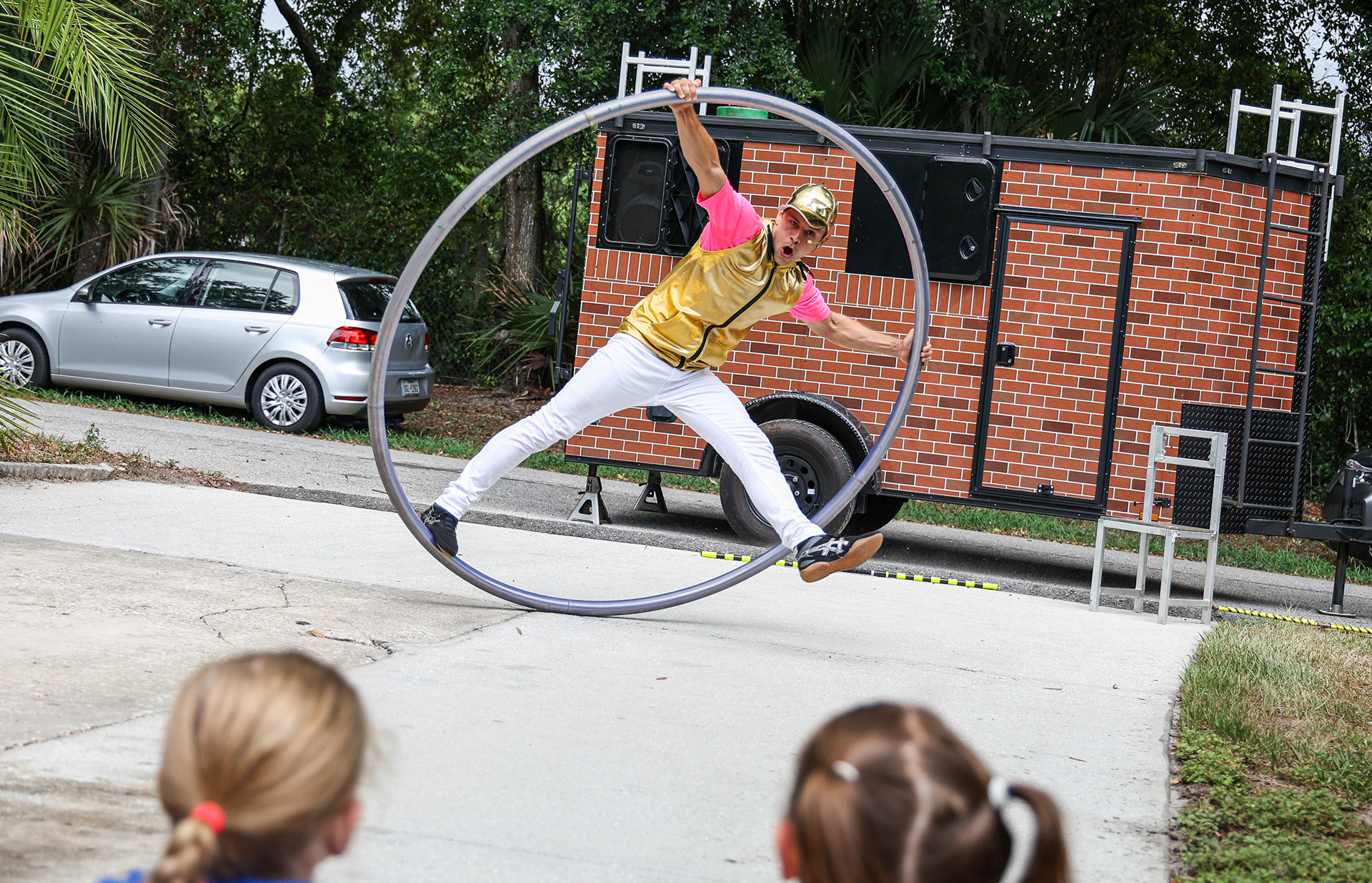 Zachary Miller, a performer with Curbside Circus, spins on a hoop at a children’s party outside a home in Orlando, Fla. Curbside Circus was an initiative by furloughed stunt performers to bring circus acts to front doors, and performed at the party on Sunday, June 13, 2021. For Orlando Sentinel.
