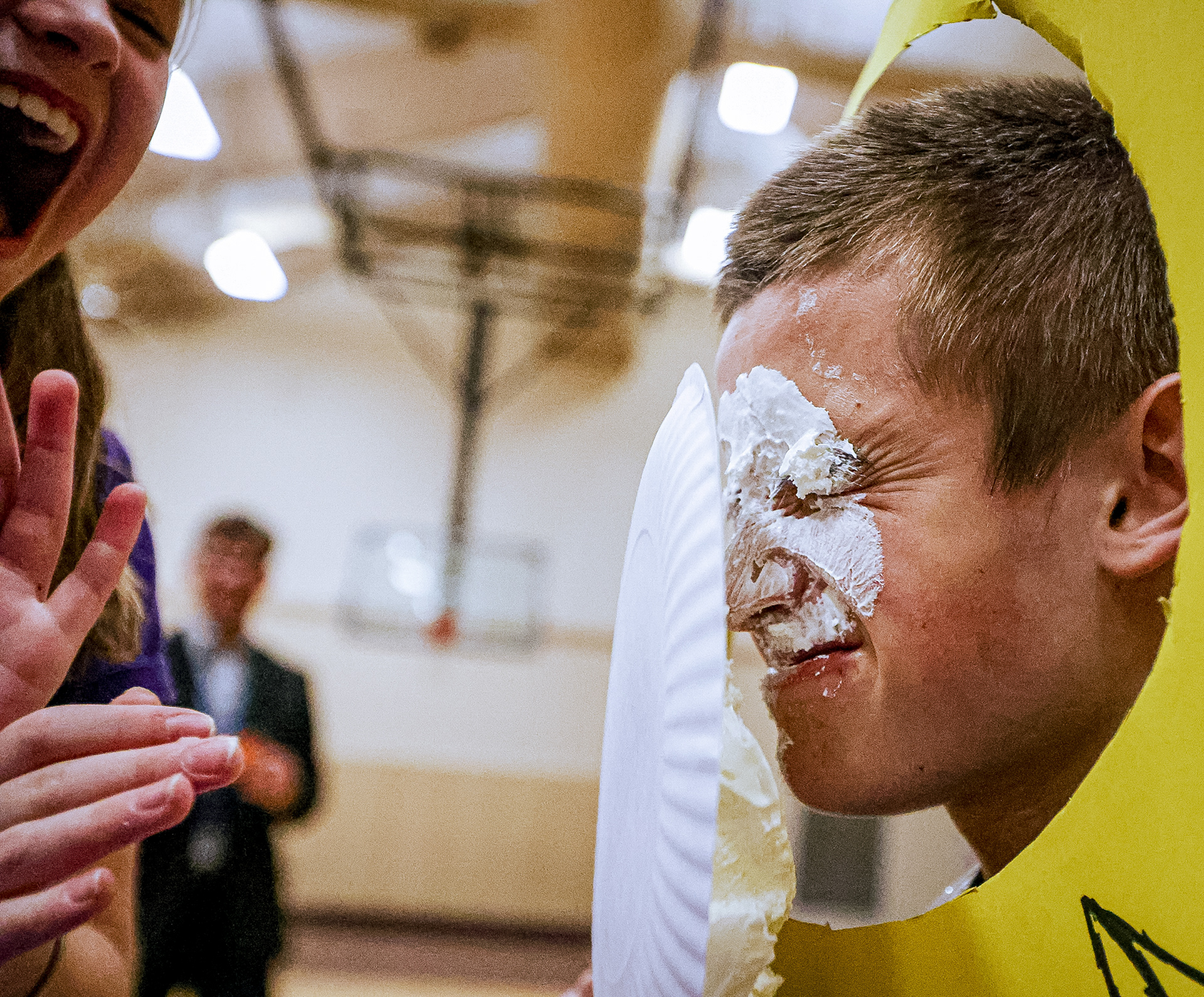 Eighth-grader Samuel Buehler, 14, is pied in the face by a third-grade classmate during a celebration after students at All Saints Catholic School in Rossford, Ohio raised more than $2000 through a Pennies for Peace Drive to benefit the people of Ukraine on Friday, April 1, 2022. For Toledo Blade.
