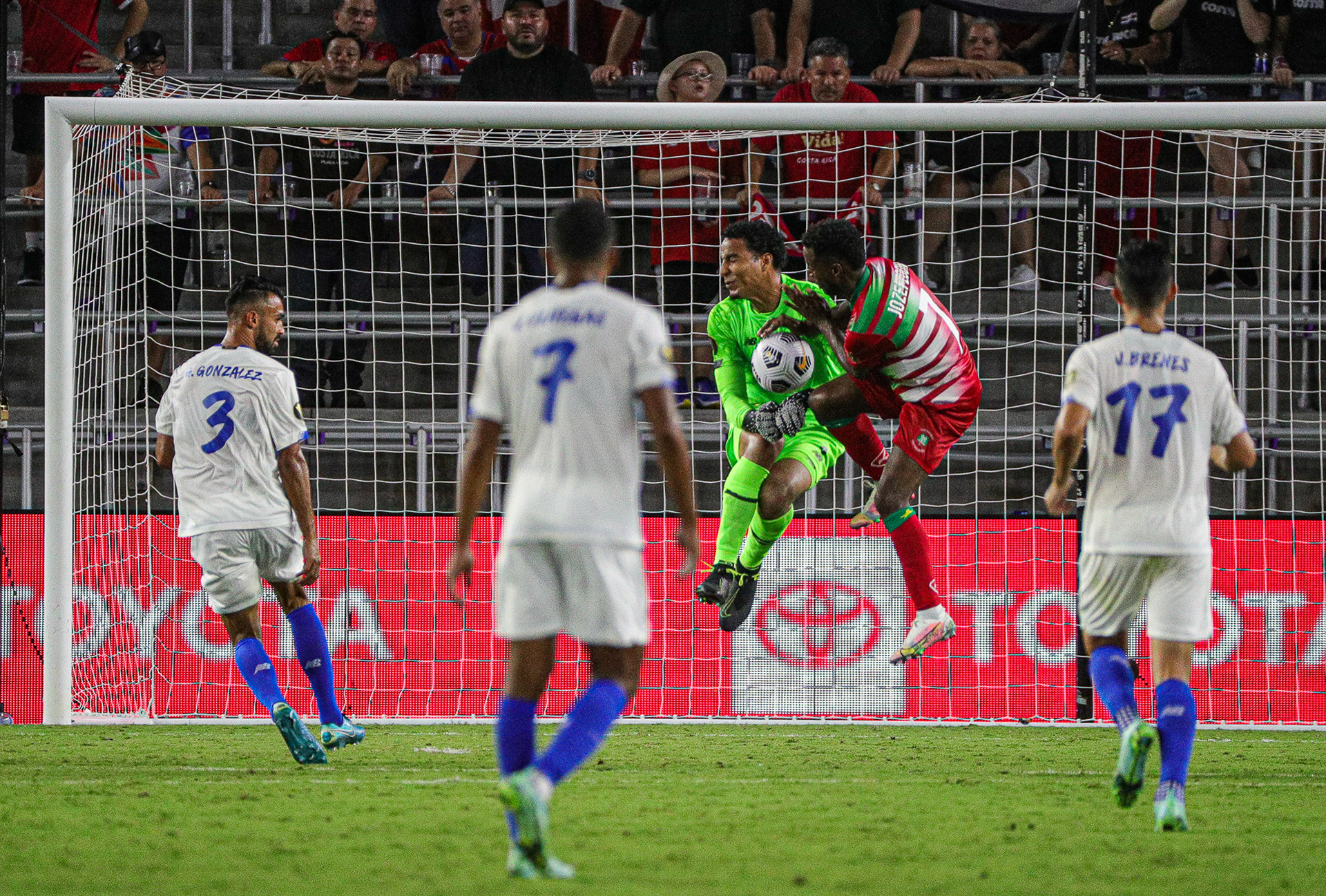 Costa Rica Goalkeeper Esteban Alvarado (1) collides with both the ball and Suriname Right Winger Florian Josefzoon (7) as Costa Rica players watch during match day two of the Gold Cup. Suriname played Costa Rica at Exploria Stadium in Orlando, Fla., on Friday, July 16, 2021 for match day two of three of the Concacaf Gold Cup.  For Orlando Sentinel.