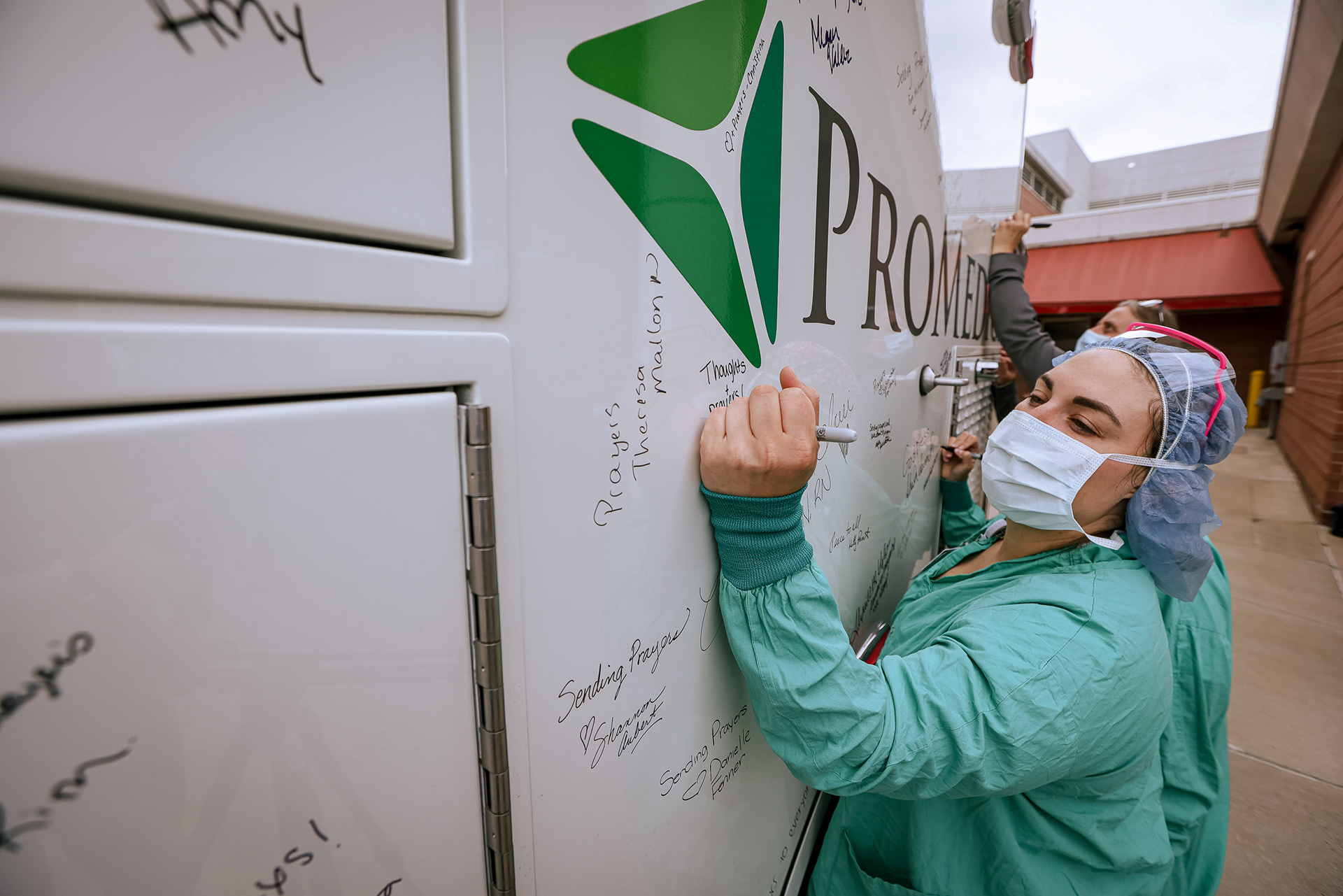 Kristen Grotz signs a supportive message on an ambulance being sent to Ukraine at ProMedica Bay Park Hospital in Oregon, Ohio on Monday, May 23, 2022. For Toledo Blade.
