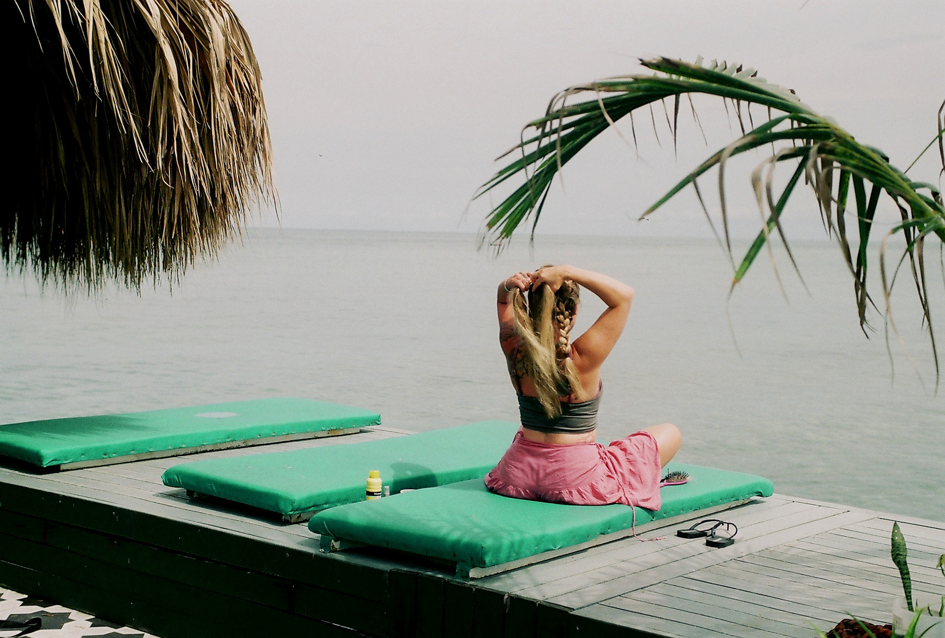 A woman braids her hair by the water off the coast of Cartagena, Colombia. 2022.