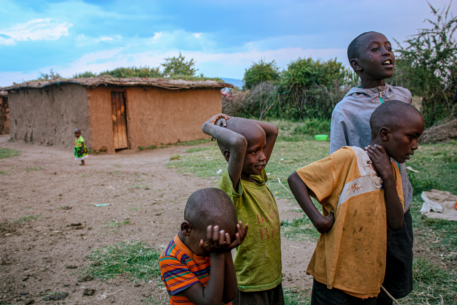 Children watch as family members dance in Maasai Mara, Kenya on July 1, 2016.