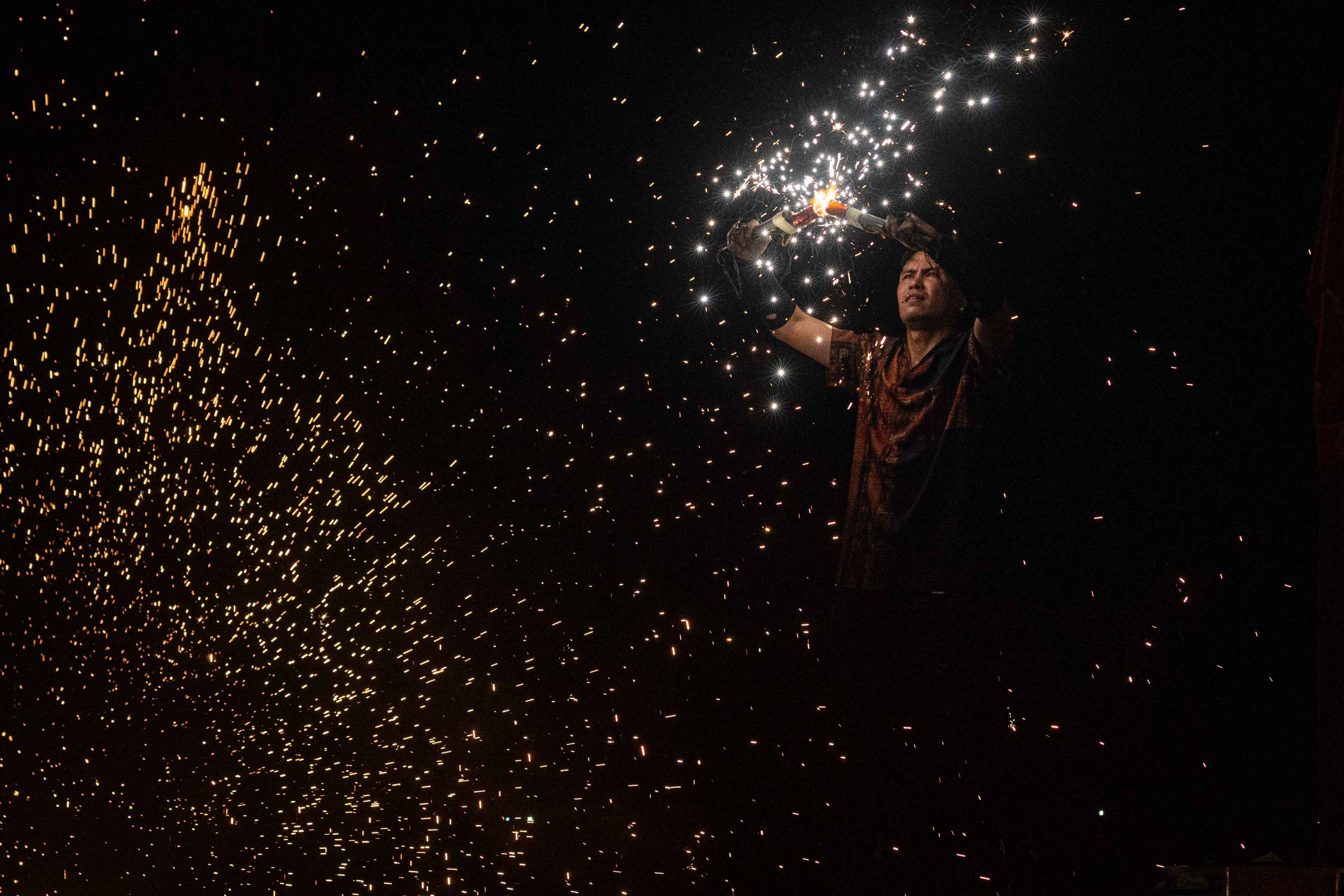 A man holds two sparklers together during a fire show performance in Phu Quoc, Vietnam.