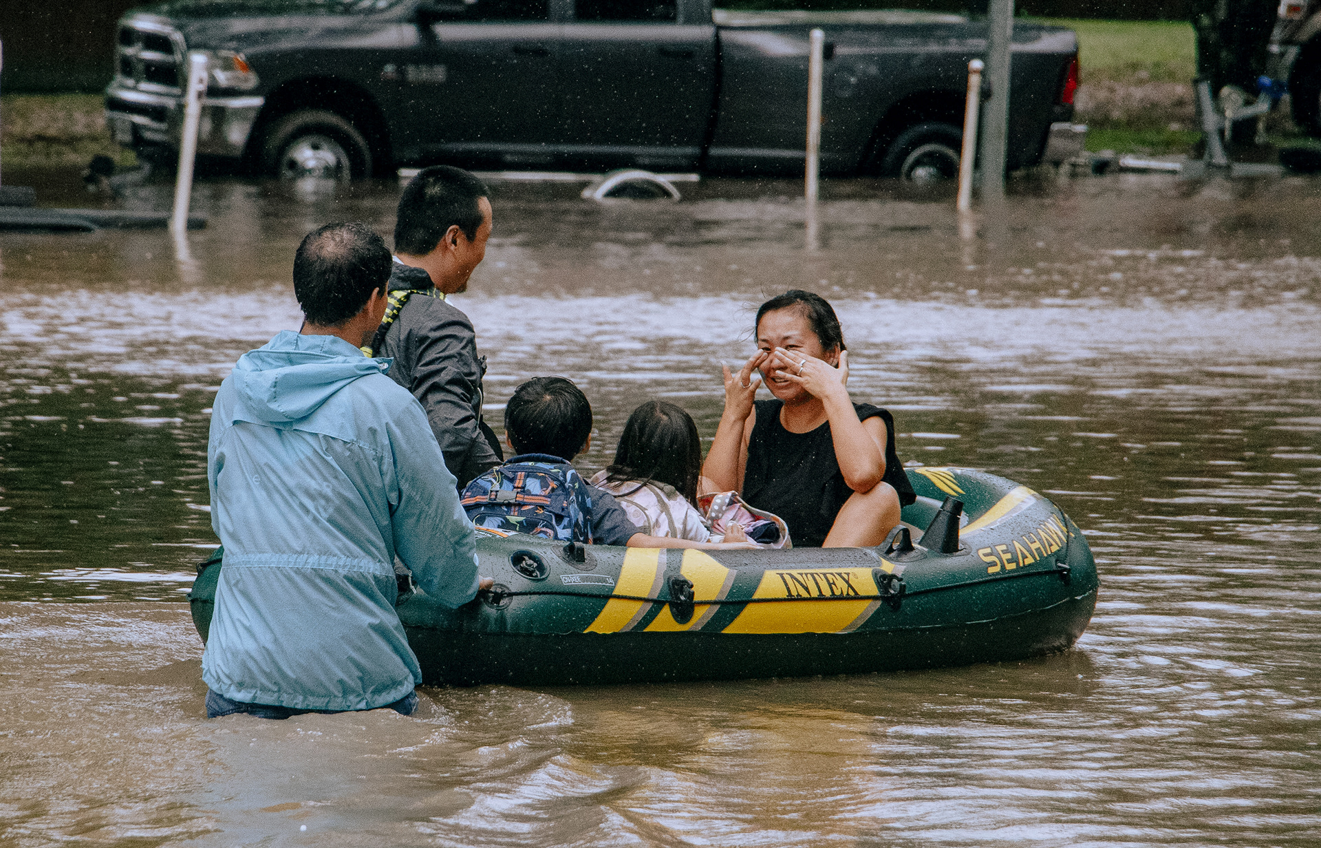 A woman wipes away tears as she and her children are helped to escape flood waters from Hurricane Harvey in Katy, Texas on August 29, 2017.
