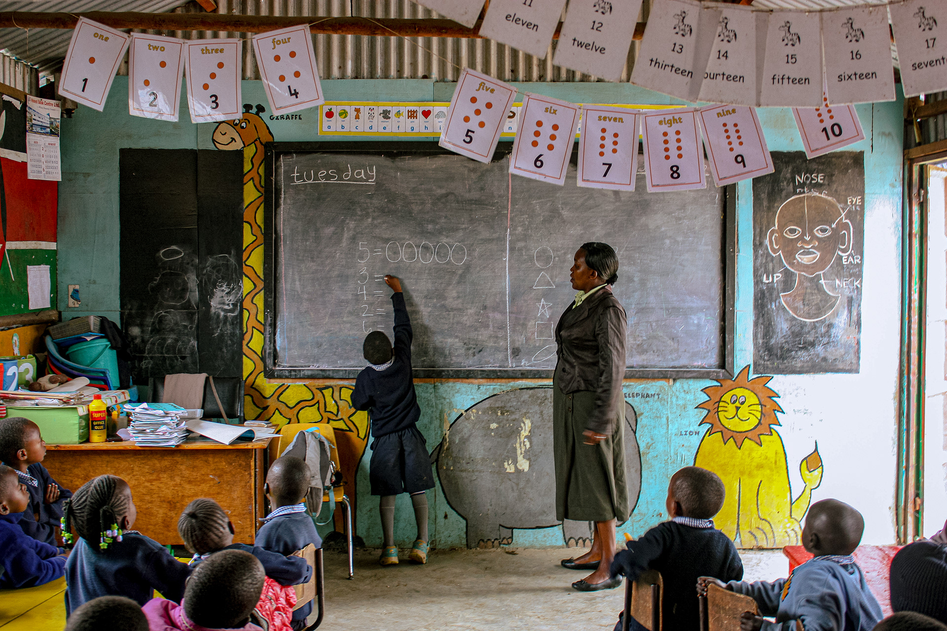 A student completes a math problem on the chalk board at The Walk Centre primary school in Nakuru, Kenya on July 17, 2016.