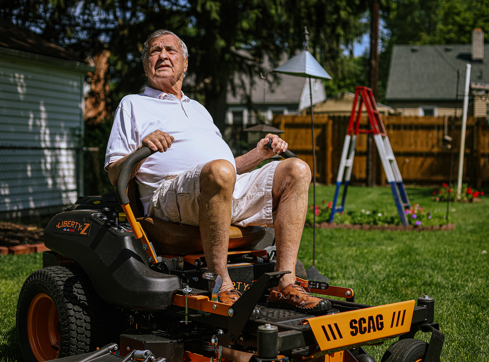 Don Couture, 90, sits on his lawn mower at his home in Toledo on Wednesday, July 13, 2022. For Toledo Blade.