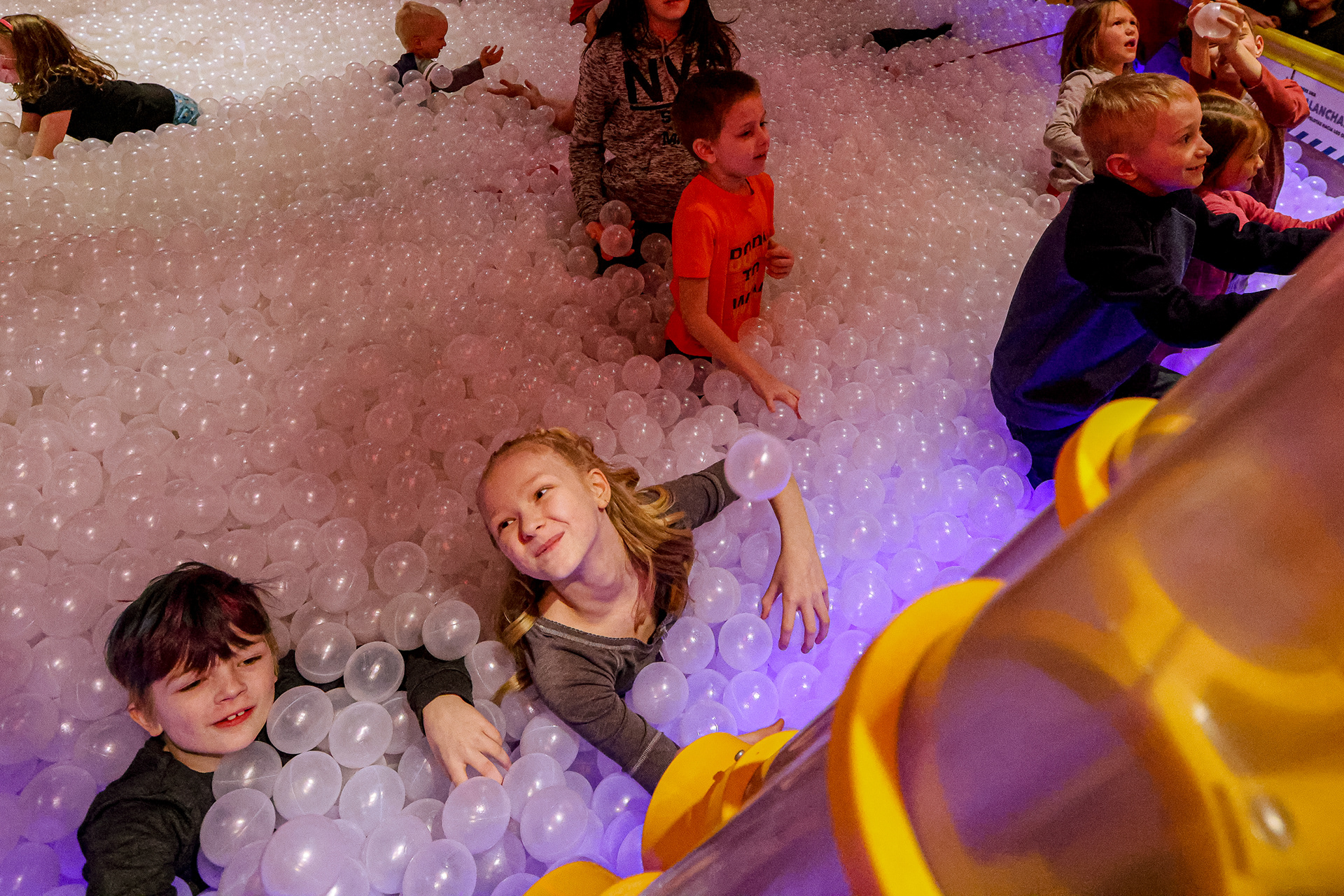 Daxton, 8, bottom left, and his sister Anna, 9, play together in the ball pit at the new Worst-Case Scenario exhibit at Imagination Station in Toledo on Thursday, February 10, 2022. For Toledo Blade.