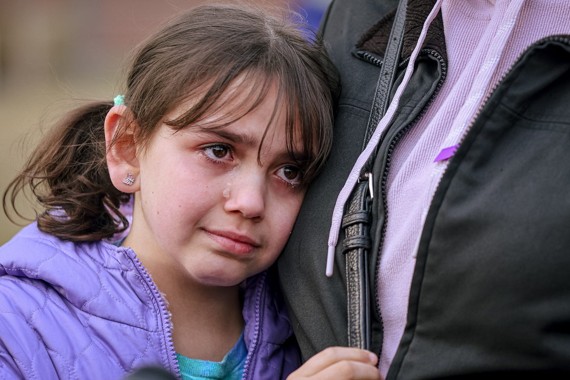 Sawson Grodi, 8, cries as she holds her mother, Lana Tabbalat, at a public gathering at The Violence Against Women Memorial Rock in Toledo to honor the lives of domestic abuse victims Ashley Darrington, Nora Pryba, Whitney Wade, and Sarah Schulte on Tuesday, March 15, 2022. For Toledo Blade.