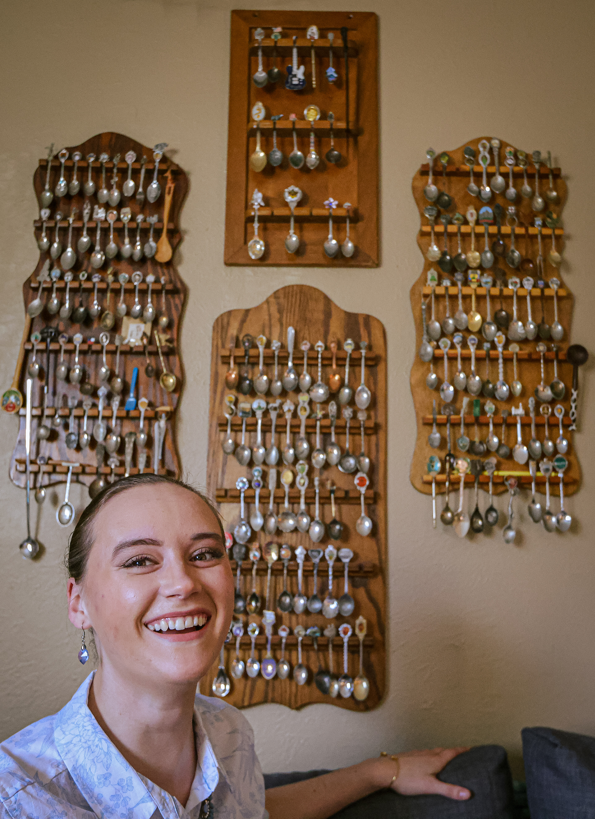 Shaelee Haaf poses with her spoon collection on display at her home in Toledo, Ohio on Monday, March 28, 2022. For Toledo Blade.