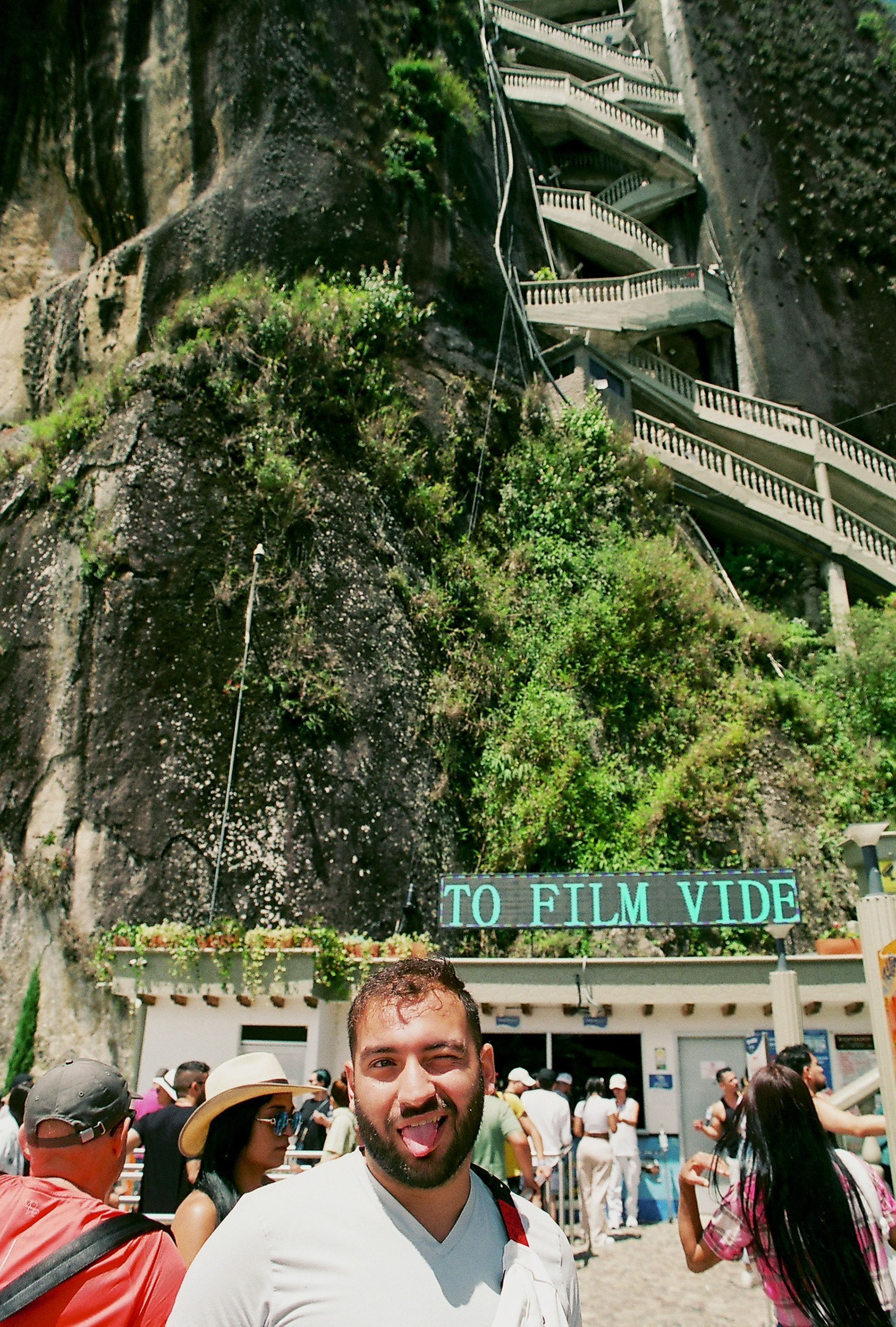 A tourist makes a face at the base of Guatapé in Colombia. 2022.
