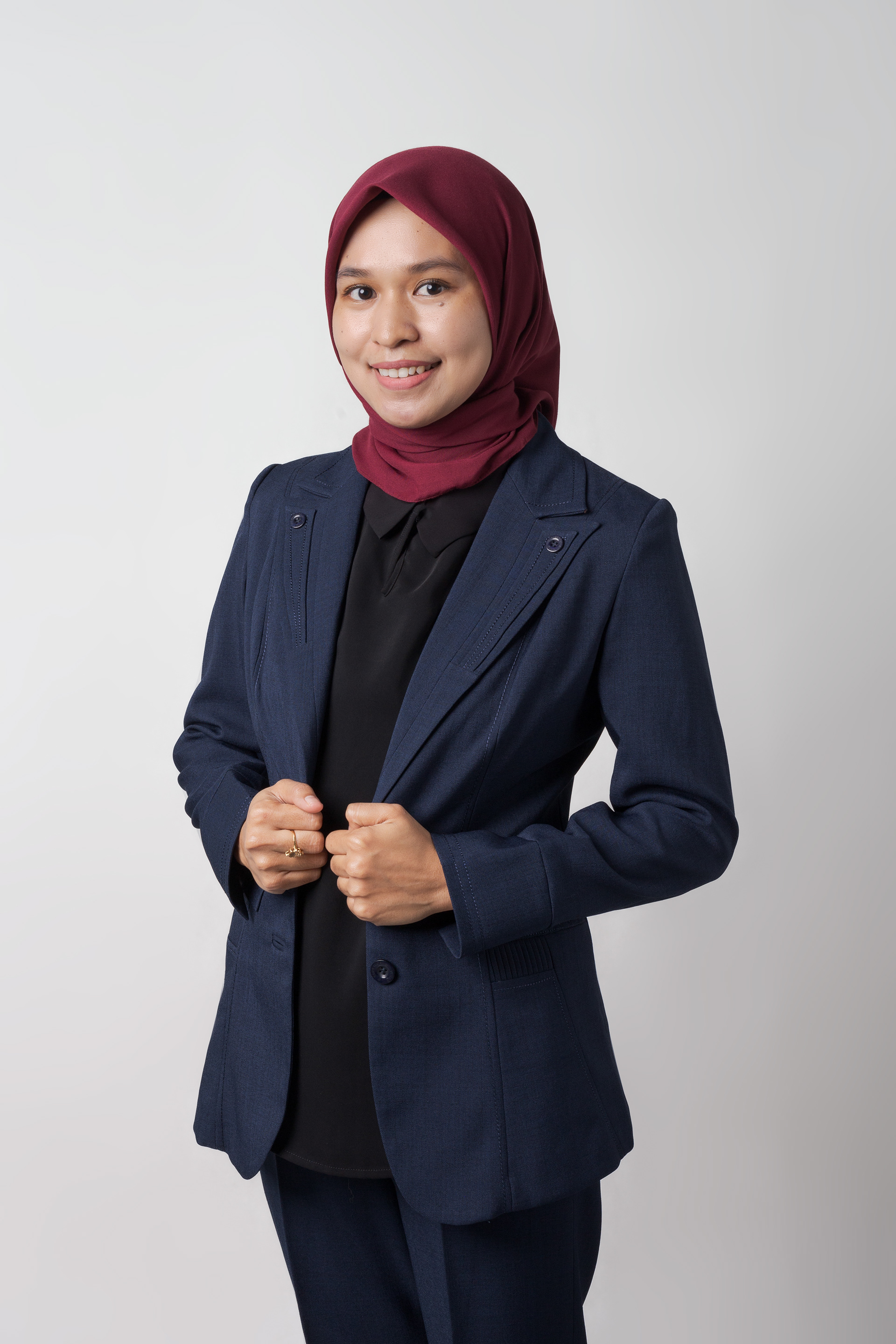 a women photograph in front of white background for id card wearing a hijab and blazer