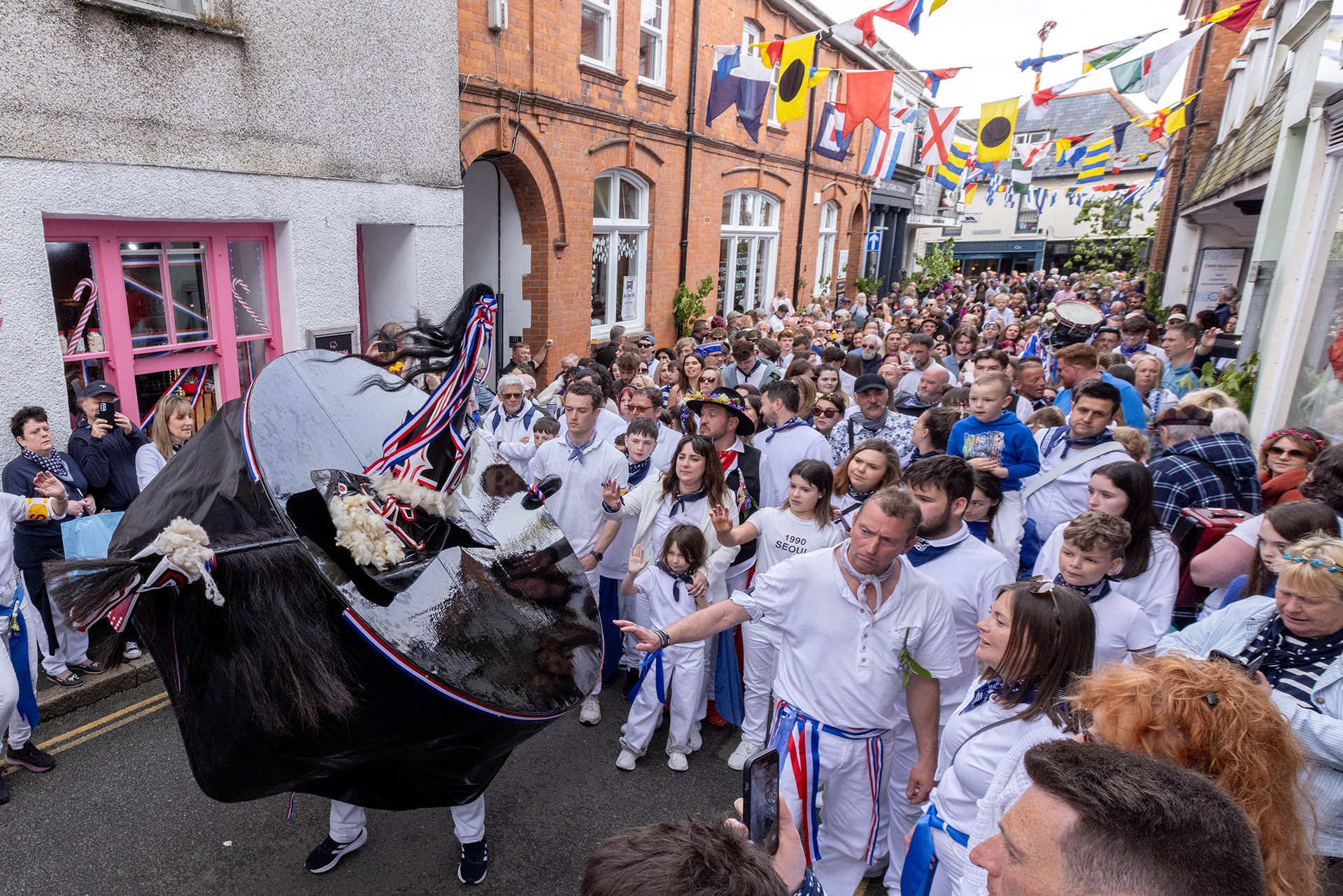 Crowds gather in the streets of Padstow for the annual May Day ‘Obby Oss’ celebrations. The tradition is seen to welcome the coming of summer and its origins are unknown, however the earliest mentions of its celebrations date back to 1803. © Luke Williams, 2024. All rights reserved.
