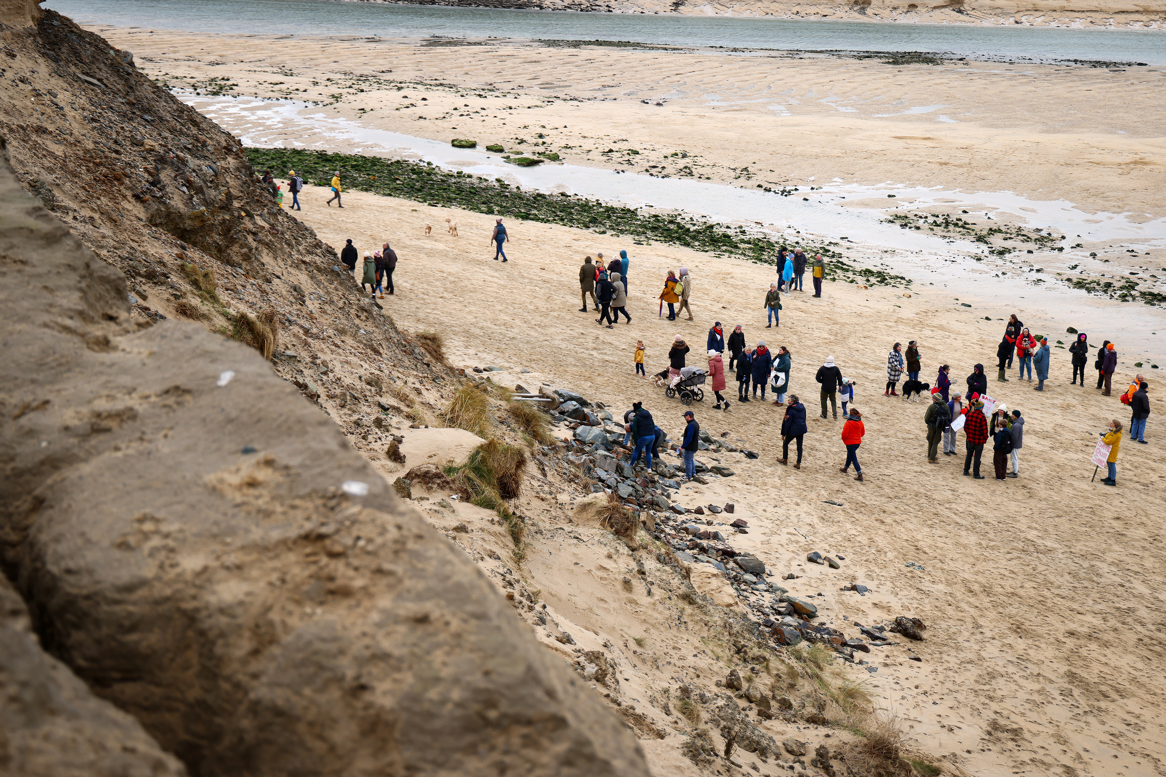 Demonstrators gather during an SOS Cornwall protest that is trying to prevent the selling off of sand from Hayle Beach in Cornwall, England. There has been outrage and concerns recently that sand is being 'stolen' from the beach. Hayle Towans Beach was voted the United Kingdom’s best beach in 2024. Shot for Stella Pictures LTD