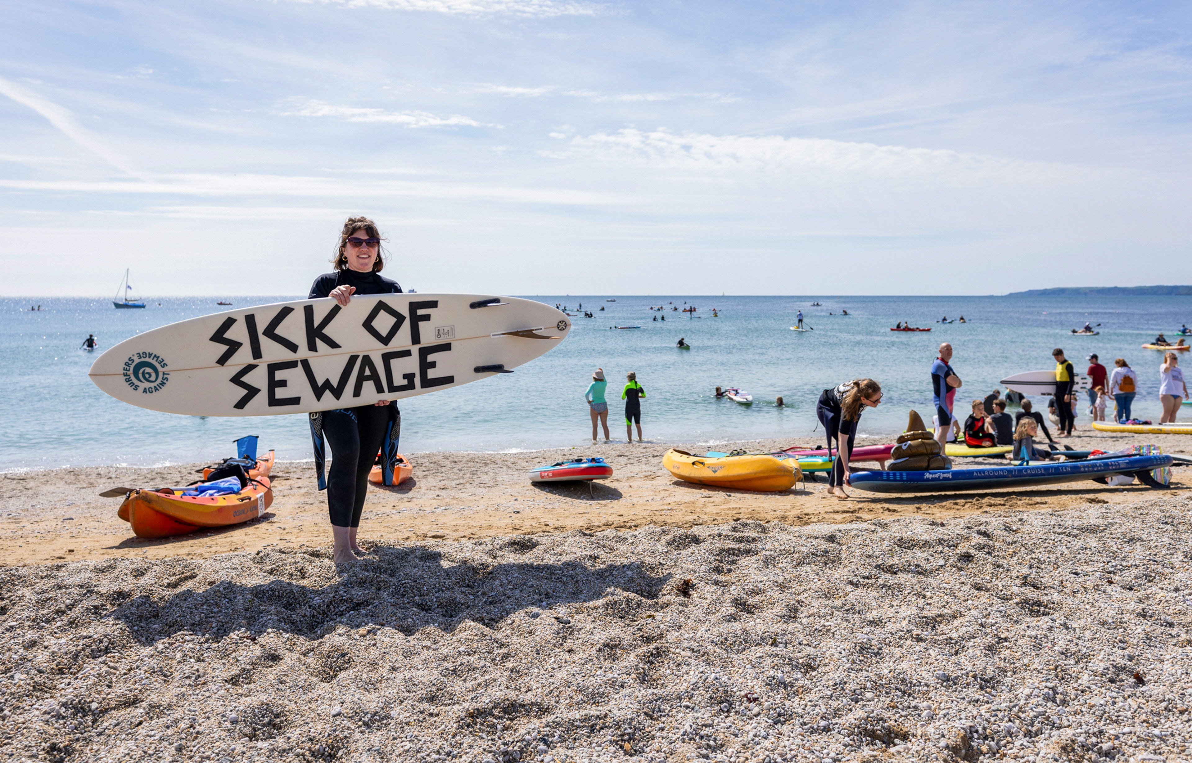 Locals take part in a Surfers Against Sewage 'paddle out' protest at Gyllyngvase Beach, Cornwall. Wanting to put an end to sewage pollution here in the UK, this was one of many paddle out protests that took place across the country. © Luke Williams, 2025. All rights reserved.