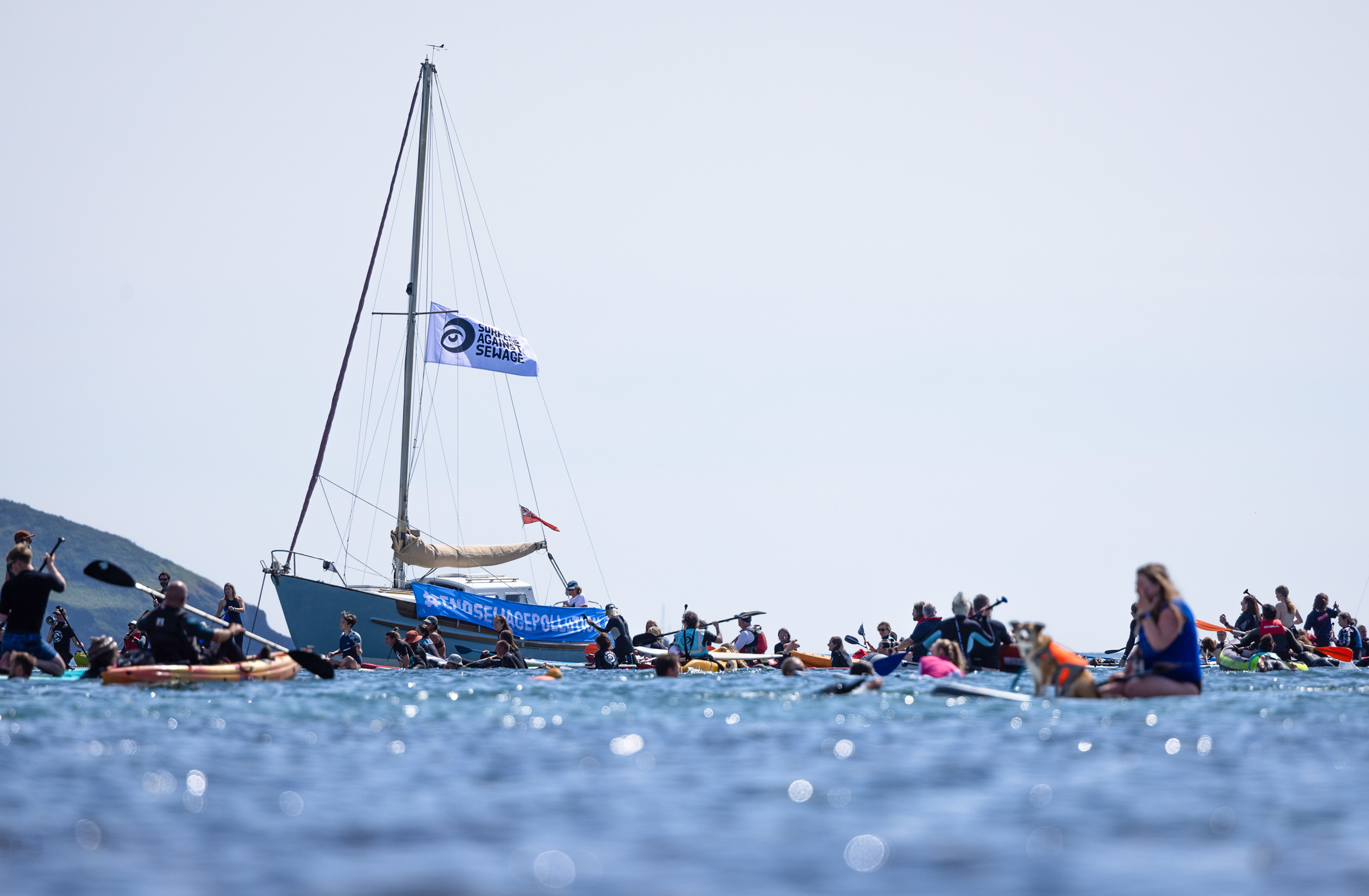 Locals take part in a Surfers Against Sewage 'paddle out' protest at Gyllyngvase Beach, Cornwall. Wanting to put an end to sewage pollution here in the UK, this was one of many paddle out protests that took place across the country. © Luke Williams, 2025. All rights reserved.