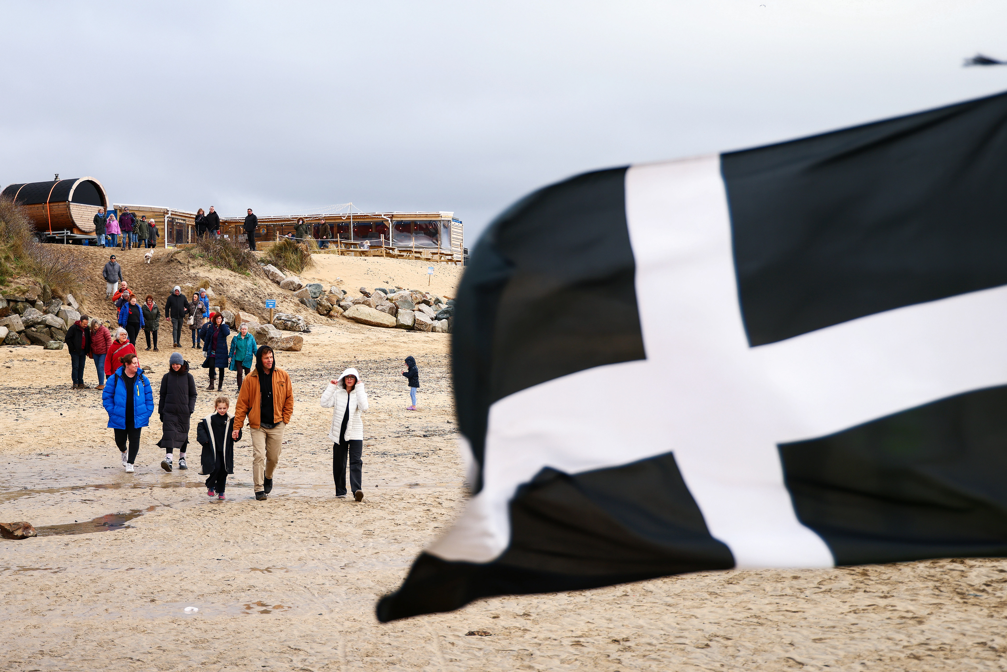 Demonstrators gather during an SOS Cornwall protest that is trying to prevent the selling off of sand from Hayle Beach in Cornwall, England. There has been outrage and concerns recently that sand is being 'stolen' from the beach. Hayle Towans Beach was voted the United Kingdom’s best beach in 2024. Shot for Stella Pictures LTD