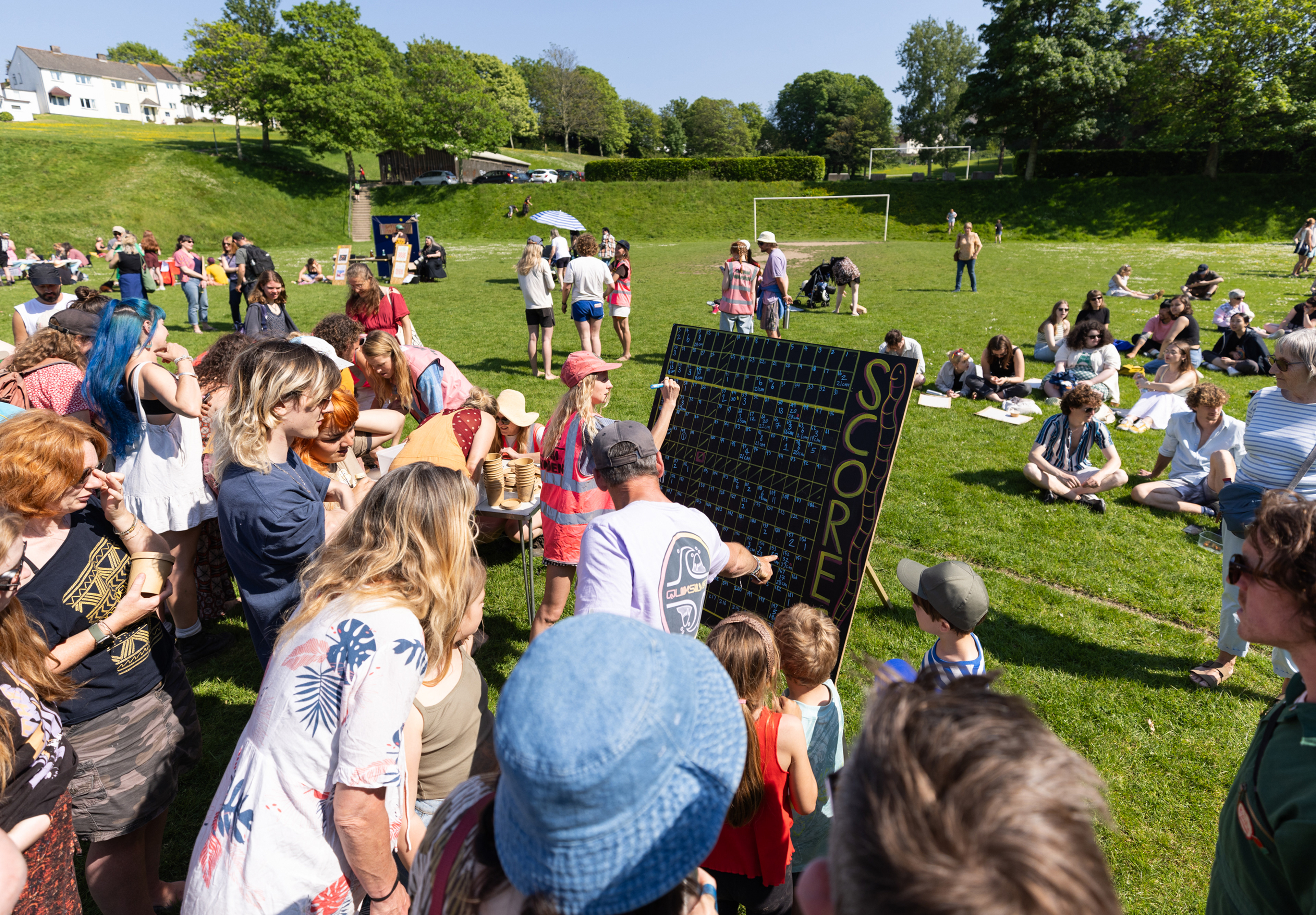 Crowds gather at the Falmouth Worm Charming Championships 2024 in Falmouth, Cornwall. The annual event organised by Georgia Gendall tasks hundreds of competitors in attempting to lure the most worms, this years winning team collected an enormous 32 worms in just 30 minutes. © Luke Williams, 2024. All rights reserved.