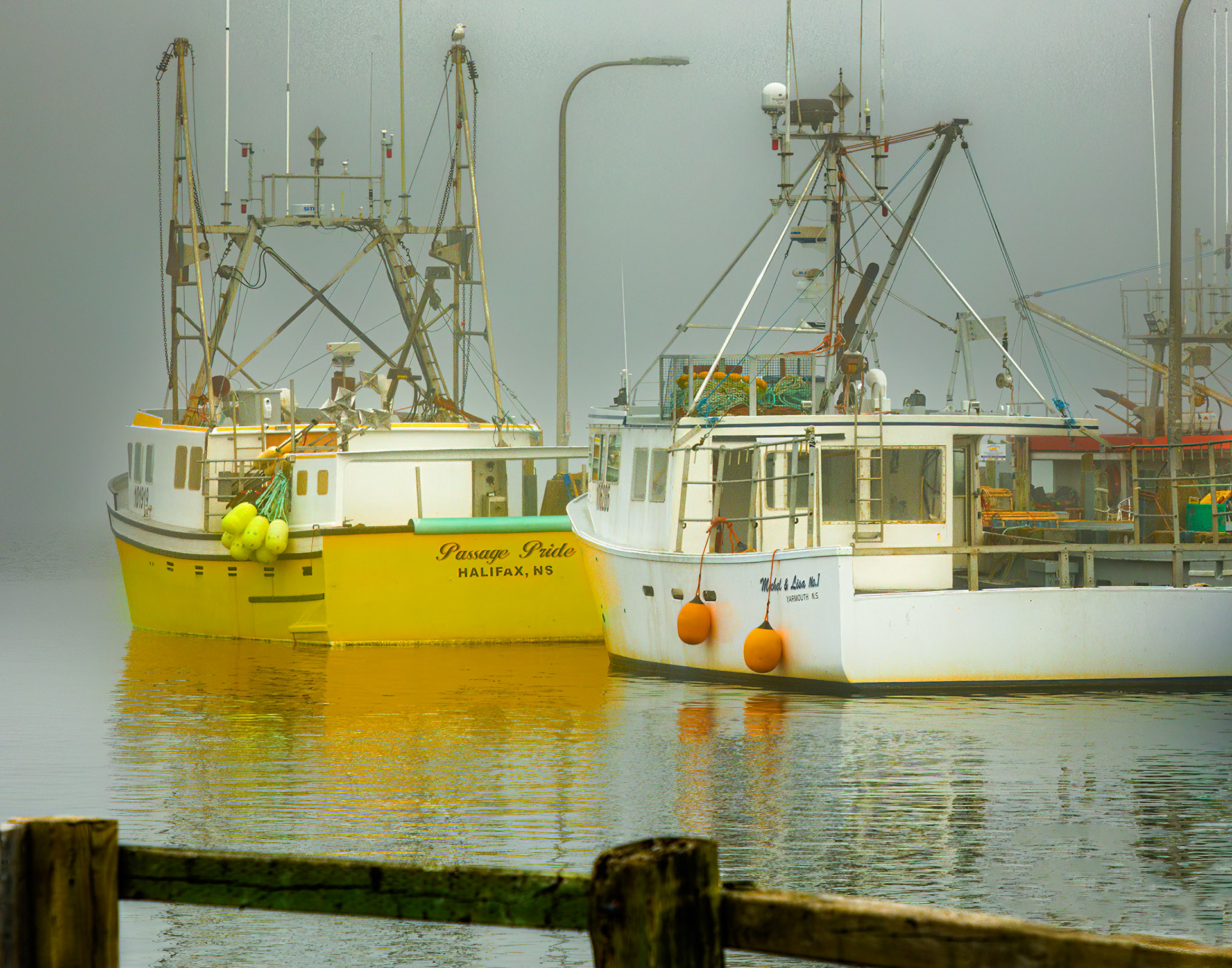 Fishing boats at rest on a foggy day in Fisherman's Cove Nova Scotia
