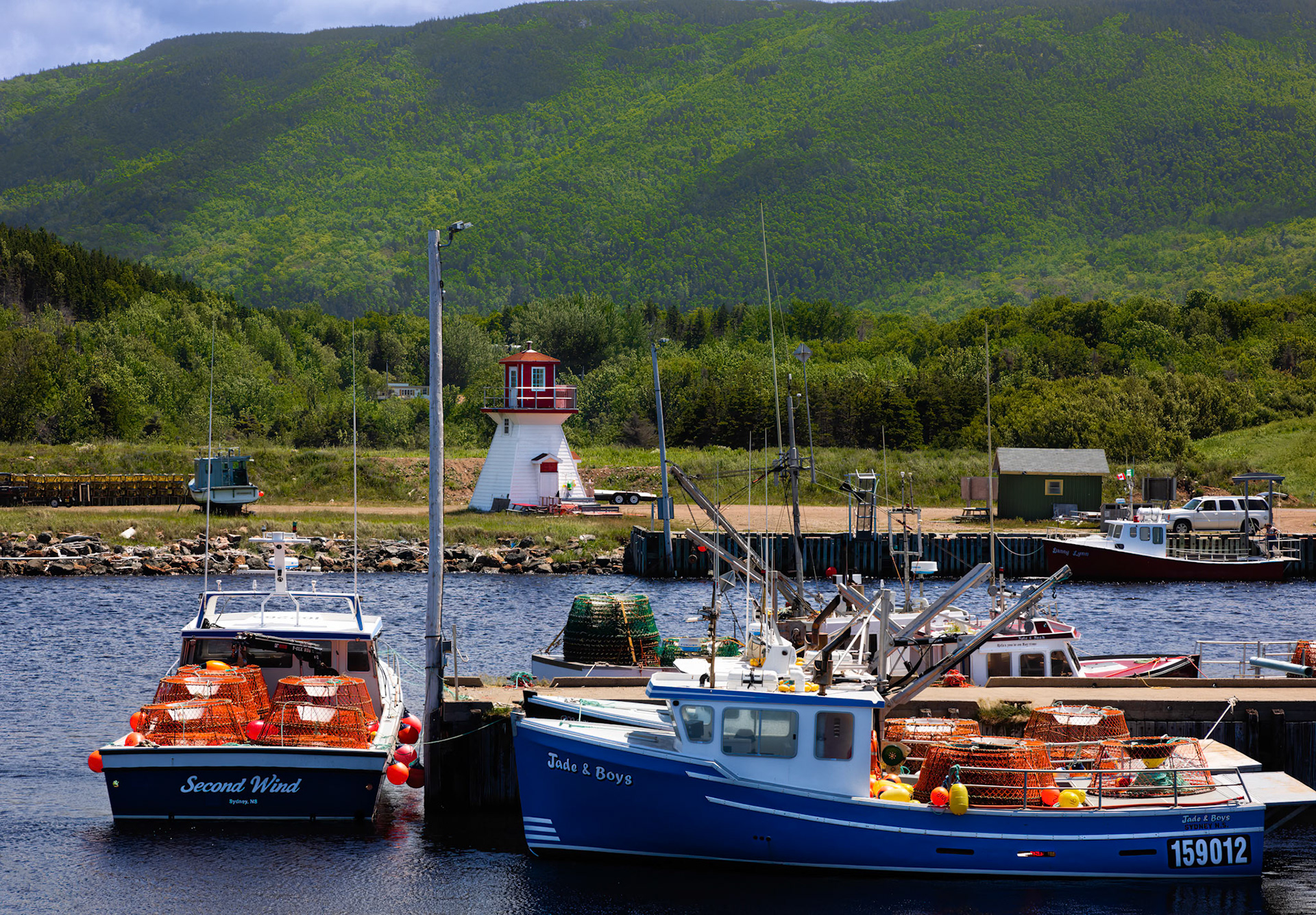 Boats and lighthouse in Pleasant Bay along Cabot Trail NS