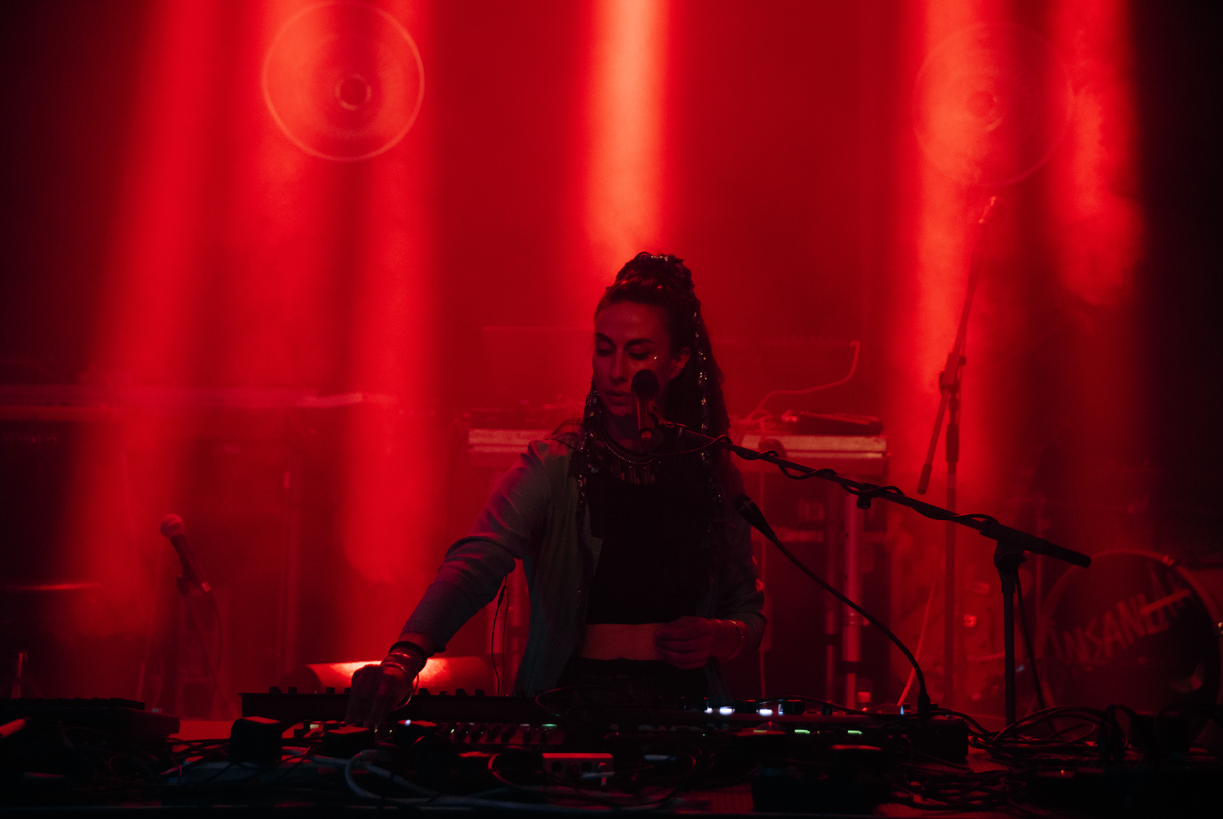 Photo of Anna Sharifi by Selin Tarakcioglu. Anna is playing while bathed in red light at Säälchen venue in Berlin