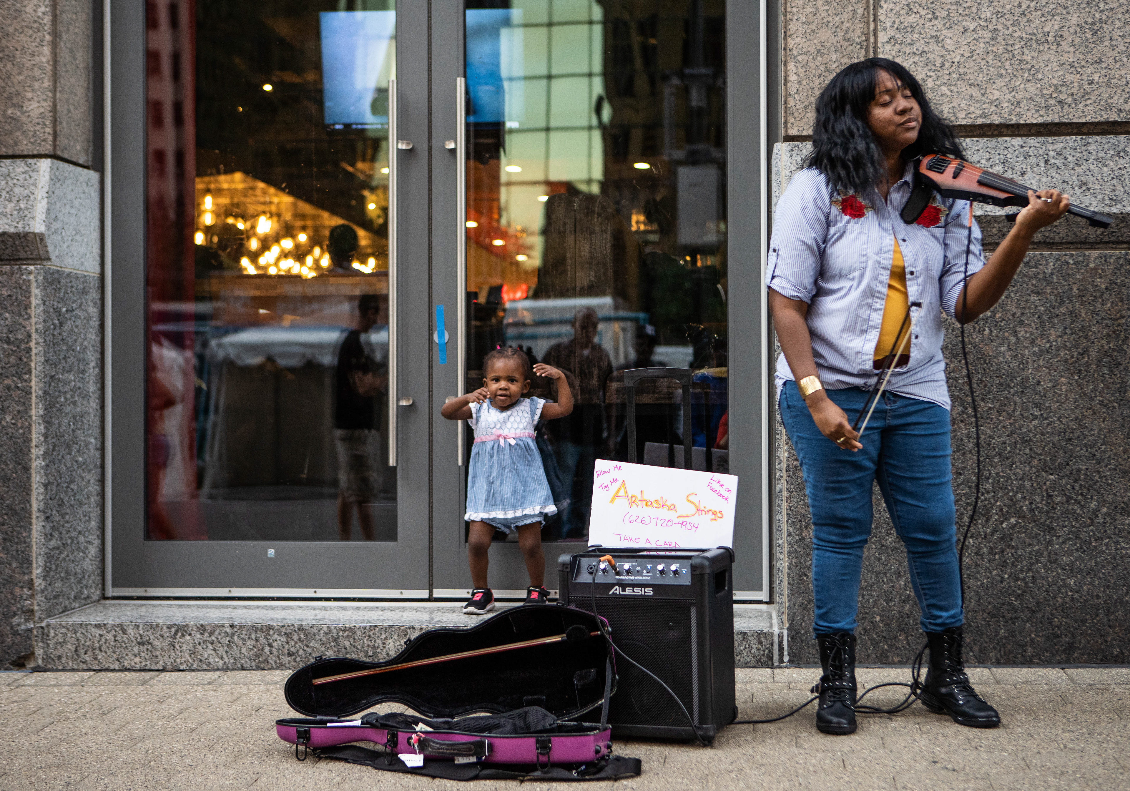 Artaska Roberts performs on Woodward Ave. while her daughter Zola dances during the 40th Annual Detroit Jazz Festival at Campus Martius Park on Friday, Aug. 30, 2019.