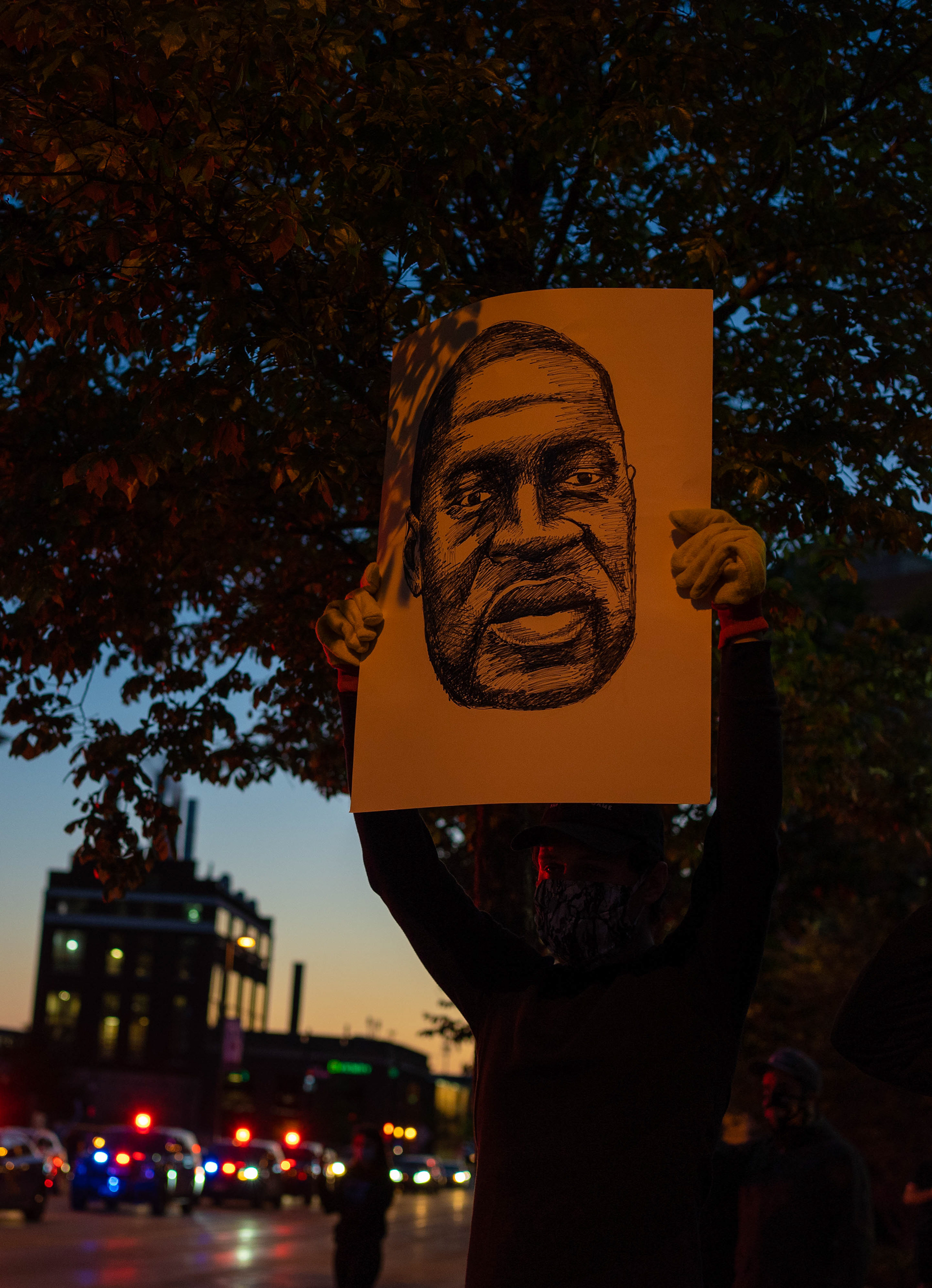 A protester holds up a drawing of George Floyd at a protest in downtown Grand Rapids on Saturday, May 30, 2020. Floyd was killed after a Minneapolis police officer kneeled on his neck for nine minutes.