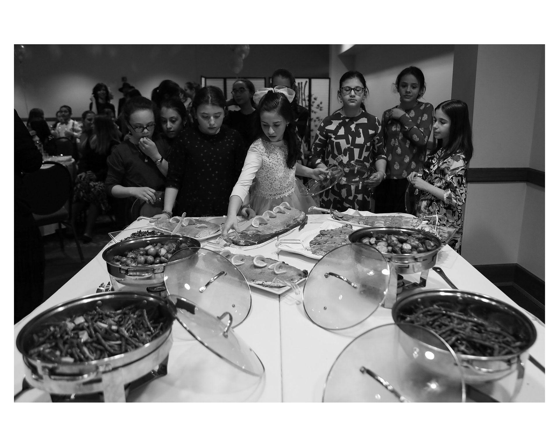 Chani and her friends are first to the buffet table to serve themselves dinner.