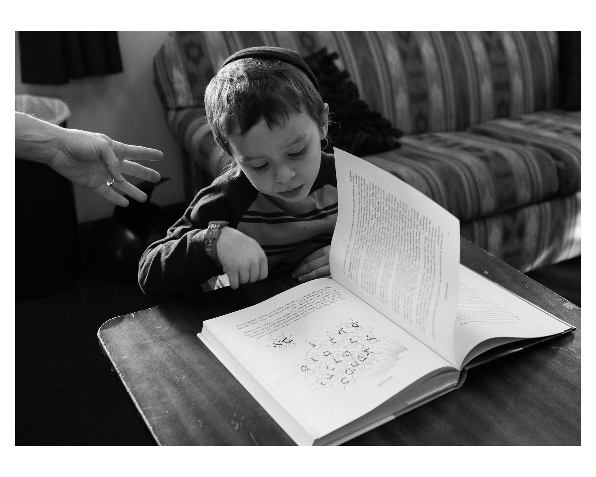 Levi Weingarten, 4, looks at pictures in a prayer book at his home.