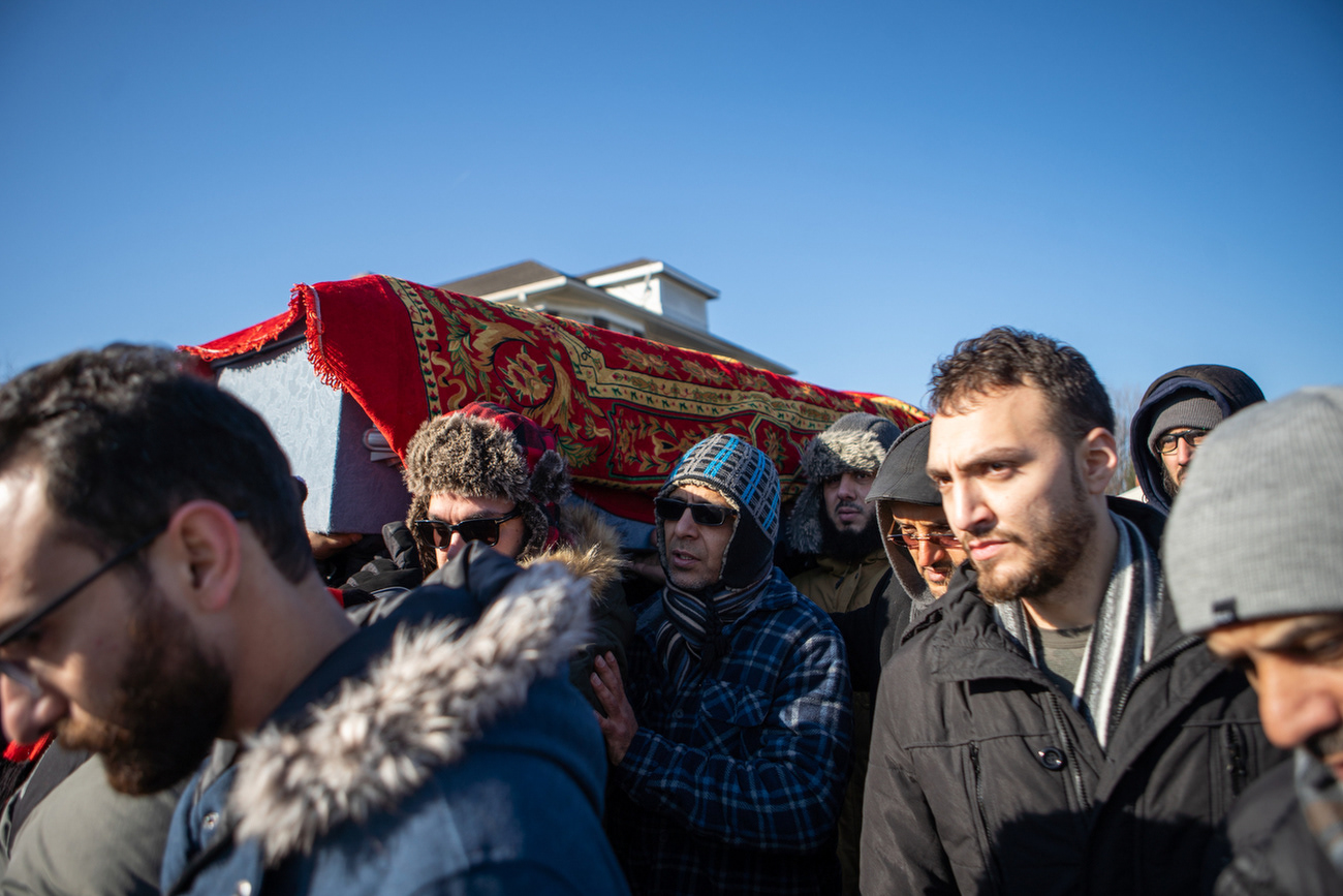 Family and community members take turns carrying the casket during the funeral for humanitarian Iman Jasim (Um Omar) at the American Moslem Society in Dearborn, Michigan on Thursday, Dec. 19, 2019.