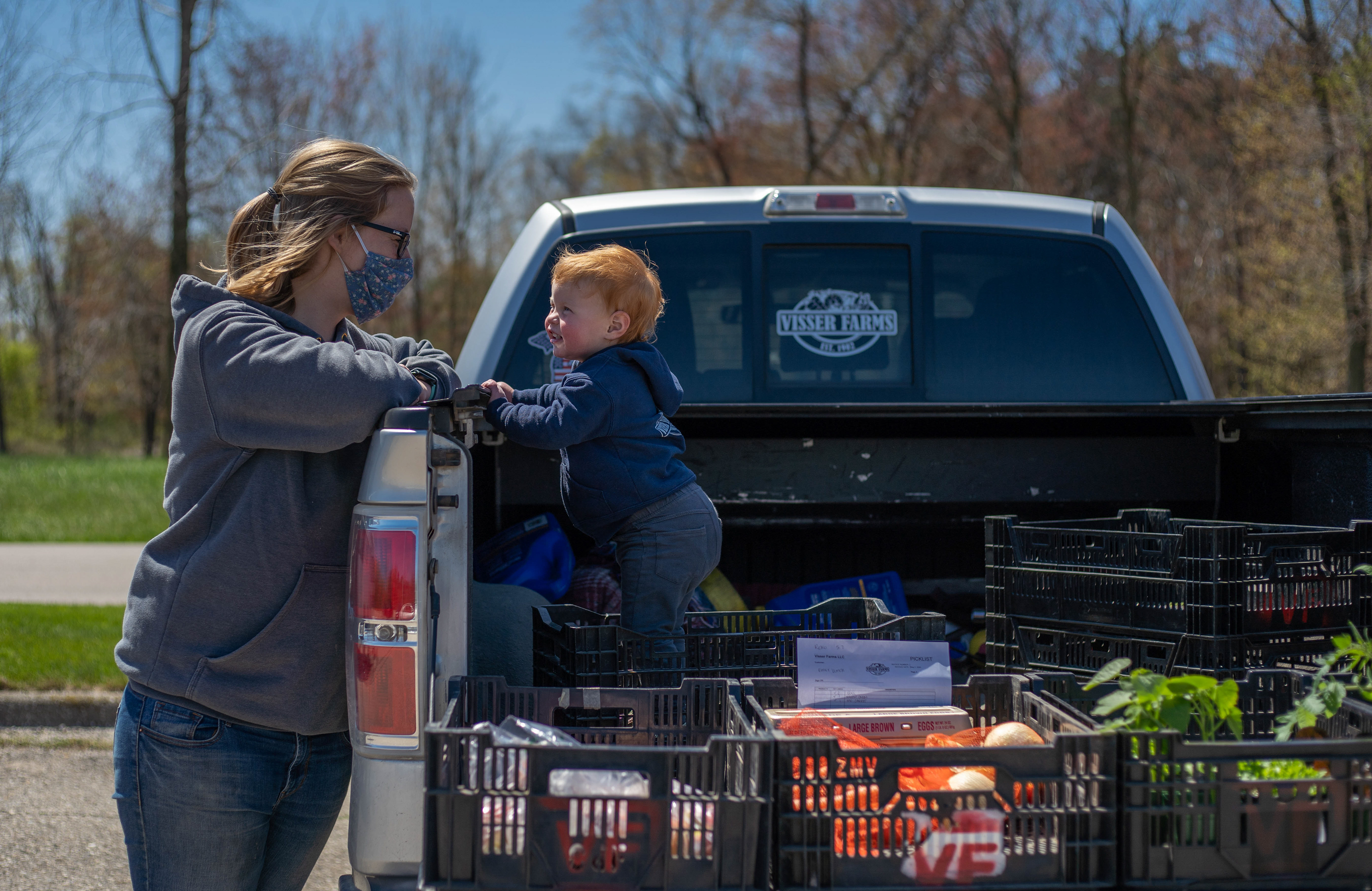 Shelby Visser and daughter Elsa wait for customers to pick up their orders at a Reko Market in Holland on Thursday, May 7, 2020.
