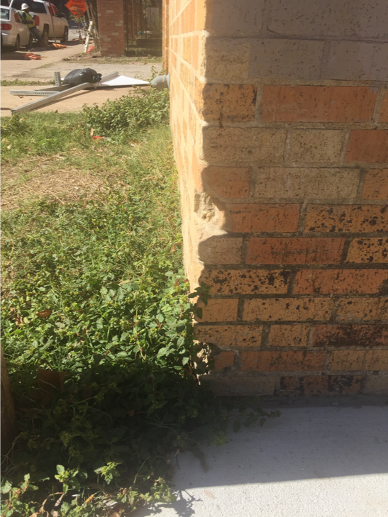 mechanical loss on lower portion of brick wall facing the alleyway entrance