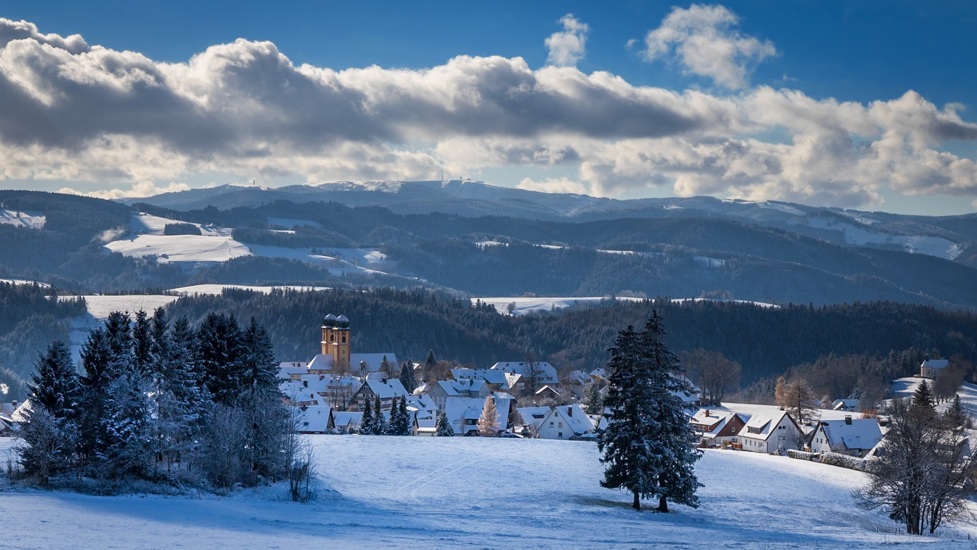 Winterlich verschneites St. Märgen mit dem Feldbergmassiv im Hintergrund