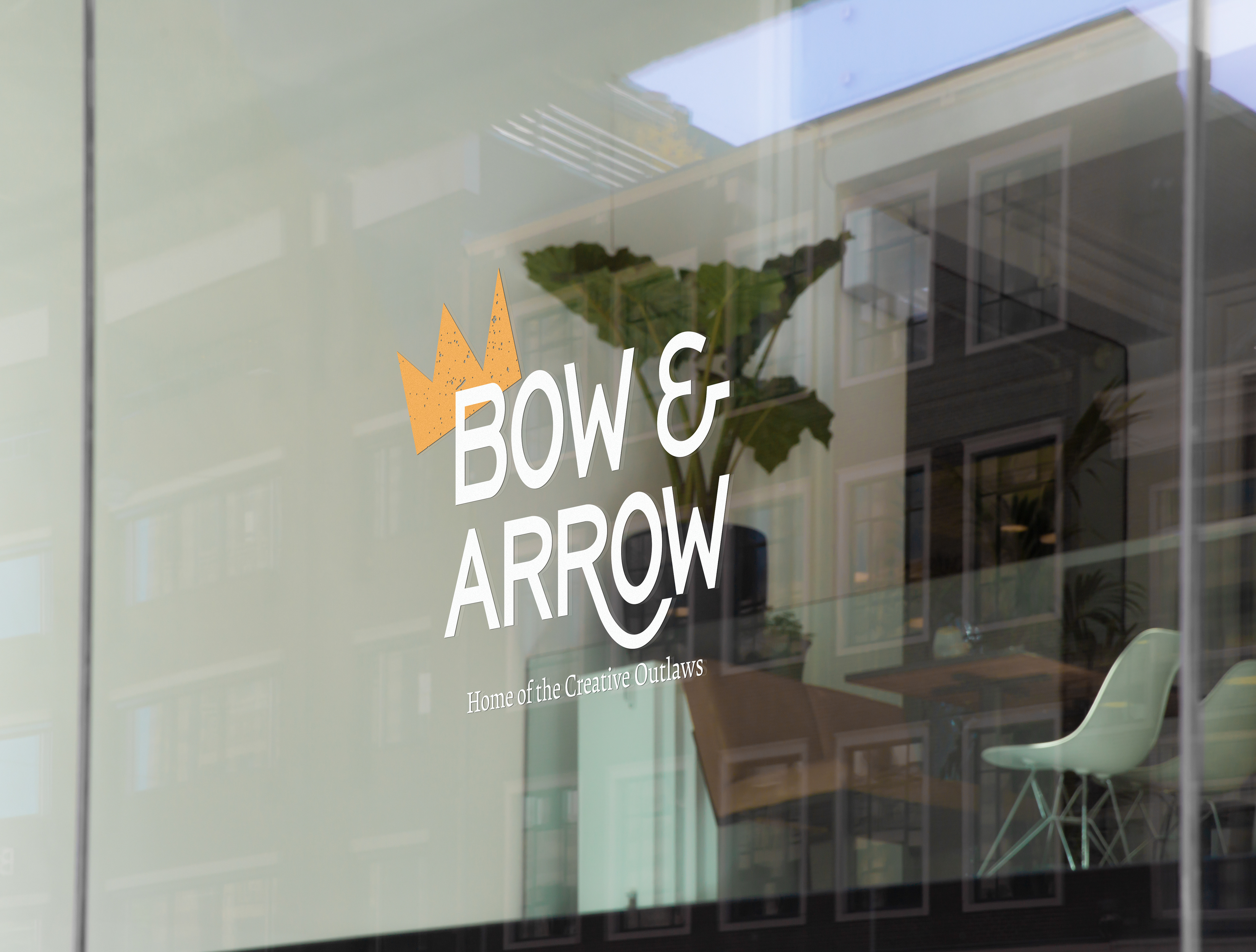 The Bow and Arrow logo that says home of the creative outlaws underneath, with crown illustration on the external co-working space window